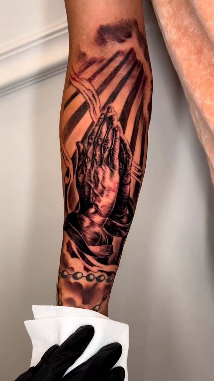 Praying hands with rosary beads realism tattoo by Sloe Rivera