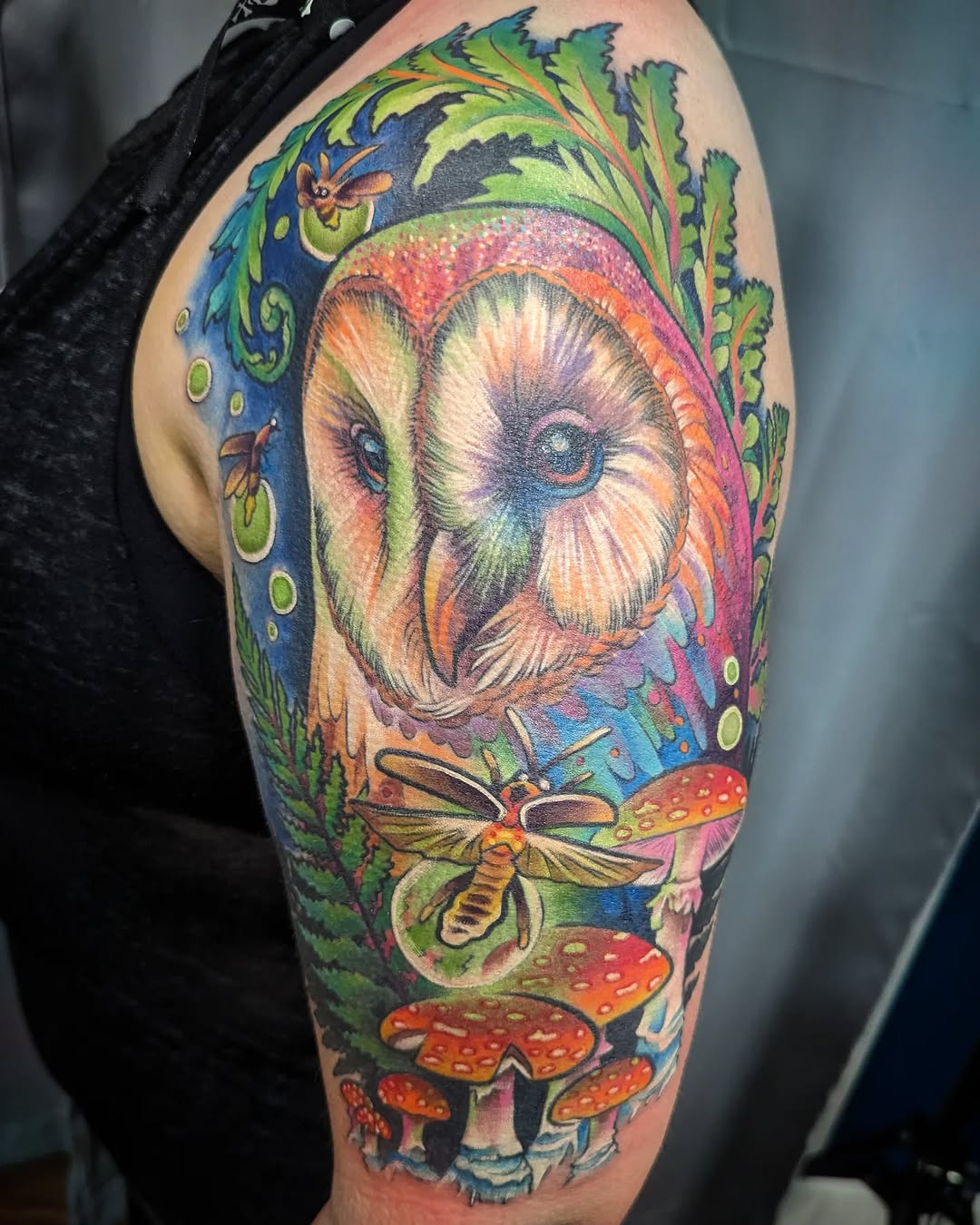 Barn owl with moth and mushrooms watercolor tattoo on the upper arm by Devon Greig