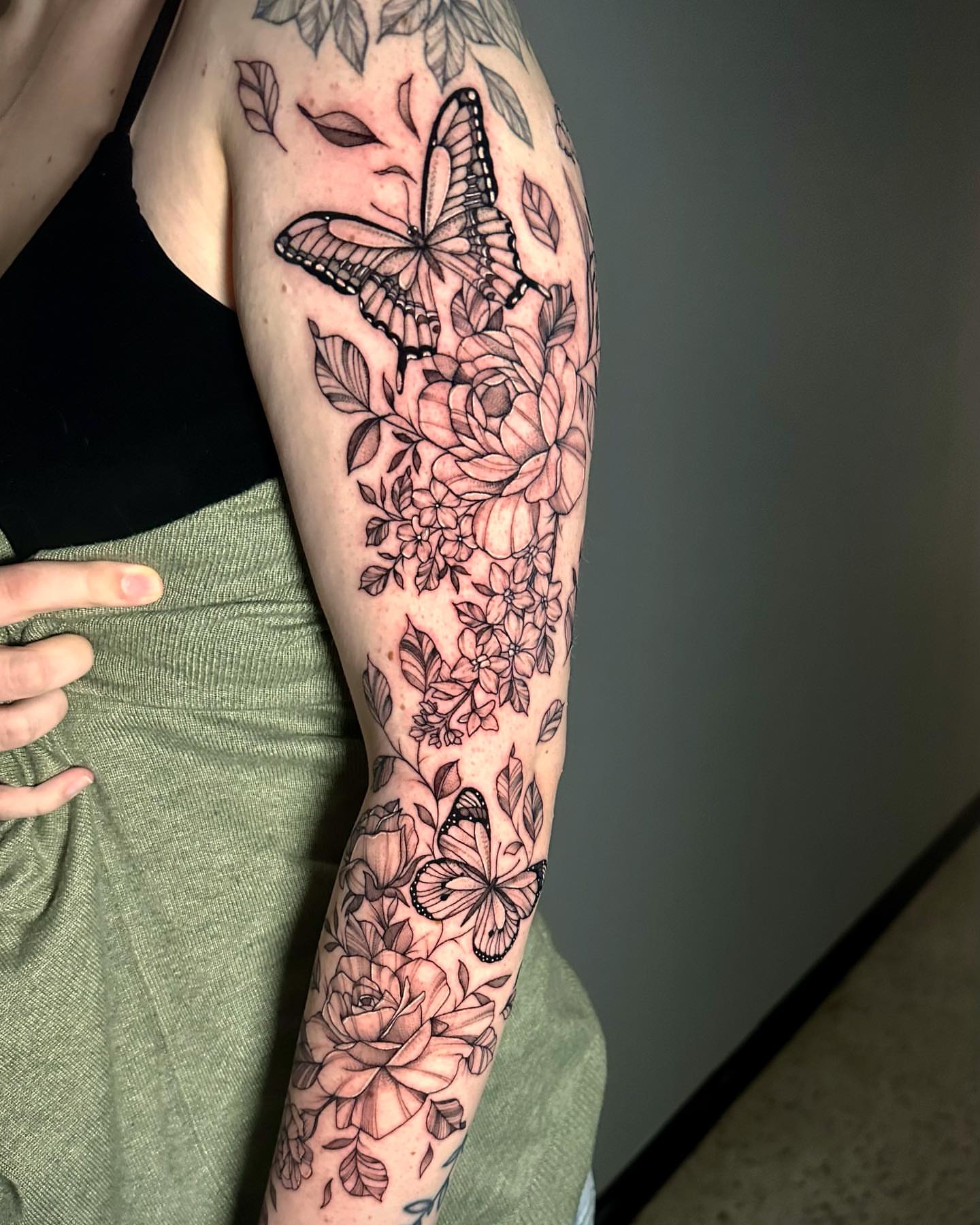 Butterfly and floral bouquet realism tattoo on the forearm by Megan McKee Tattoo Artist