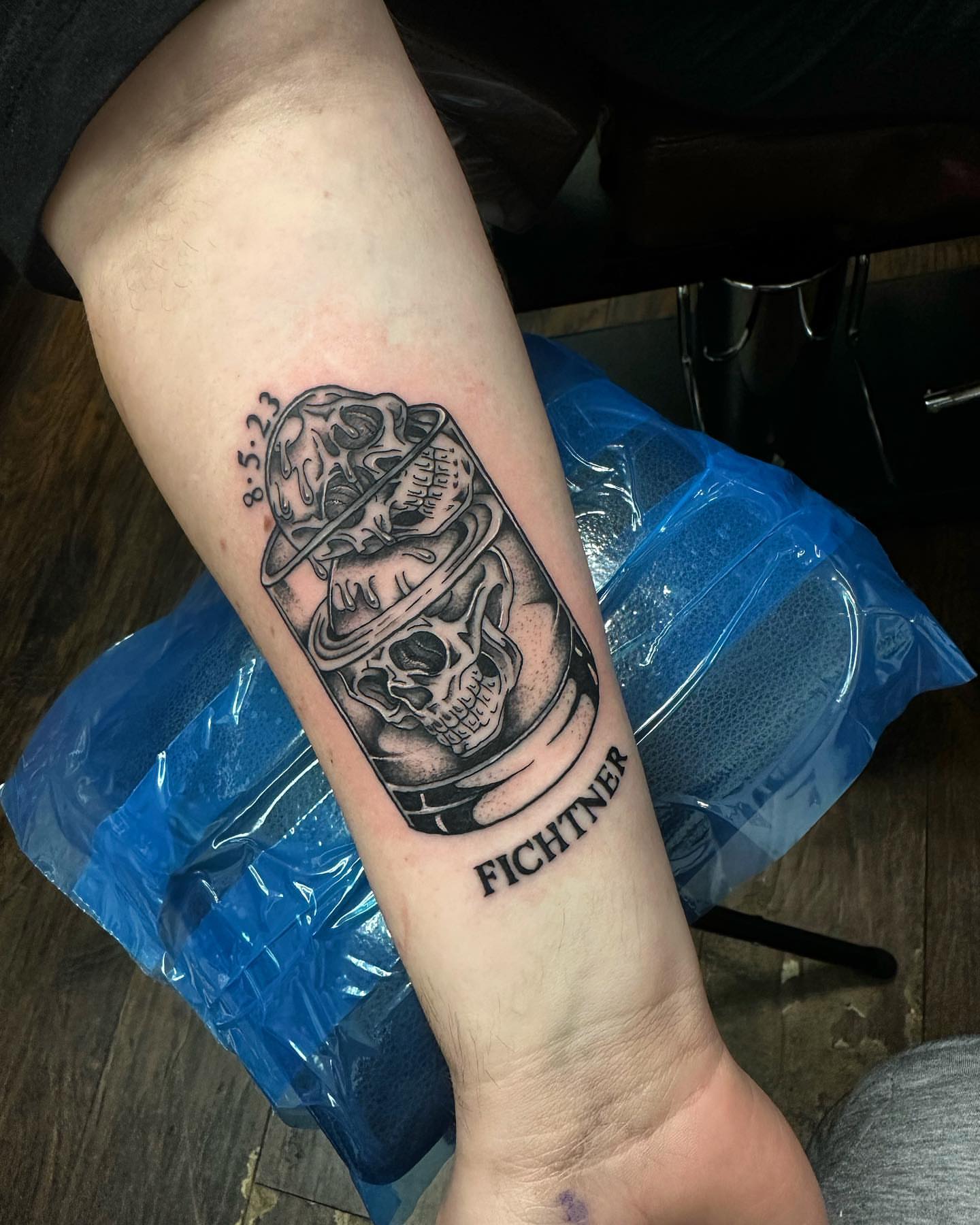 Skull and firefighter helmet black and grey tattoo on the forearm by Kassie Perian