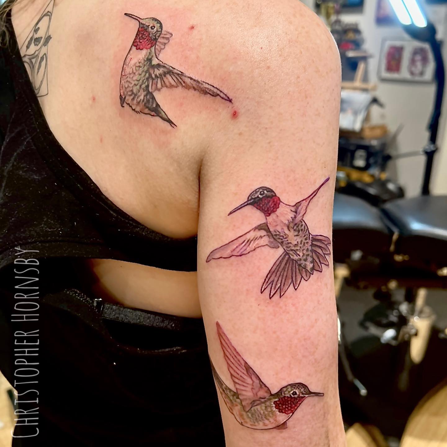 Hummingbirds realism tattoo on the upper arm by Chris Hornsby
