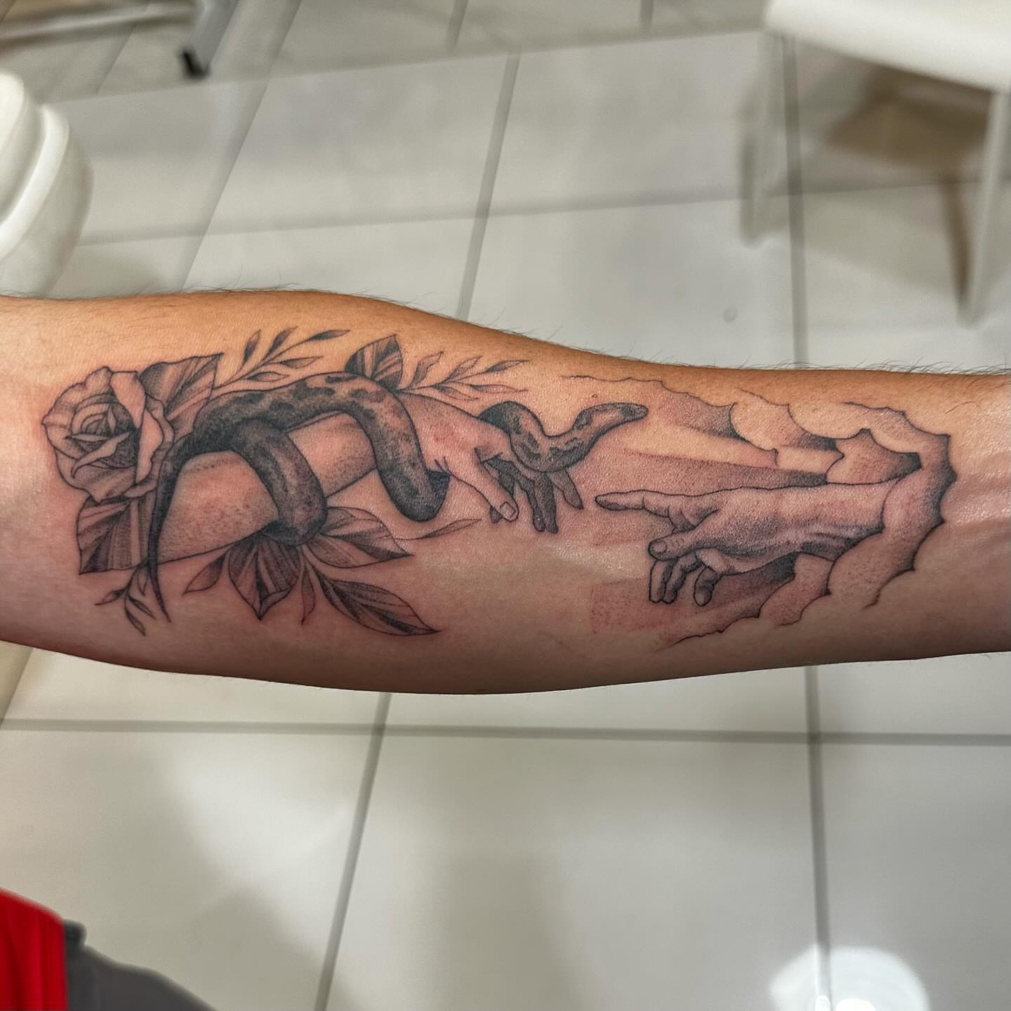 Snake and peony realism tattoo on the forearm by Raul Najera Tattoo, Plano, Texas