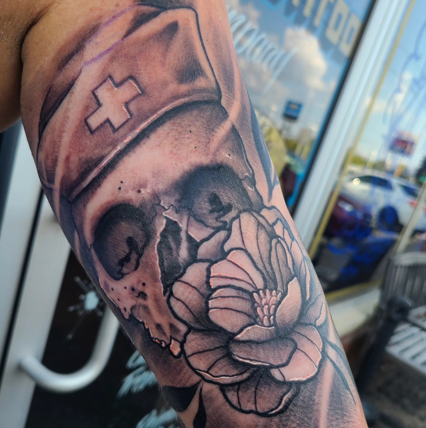 Skull and flower realism tattoo on the forearm by David Johnson