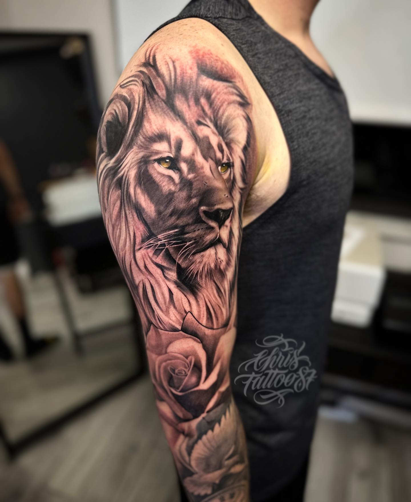 Lion and rose realism tattoo on the upper arm by chris tattoo