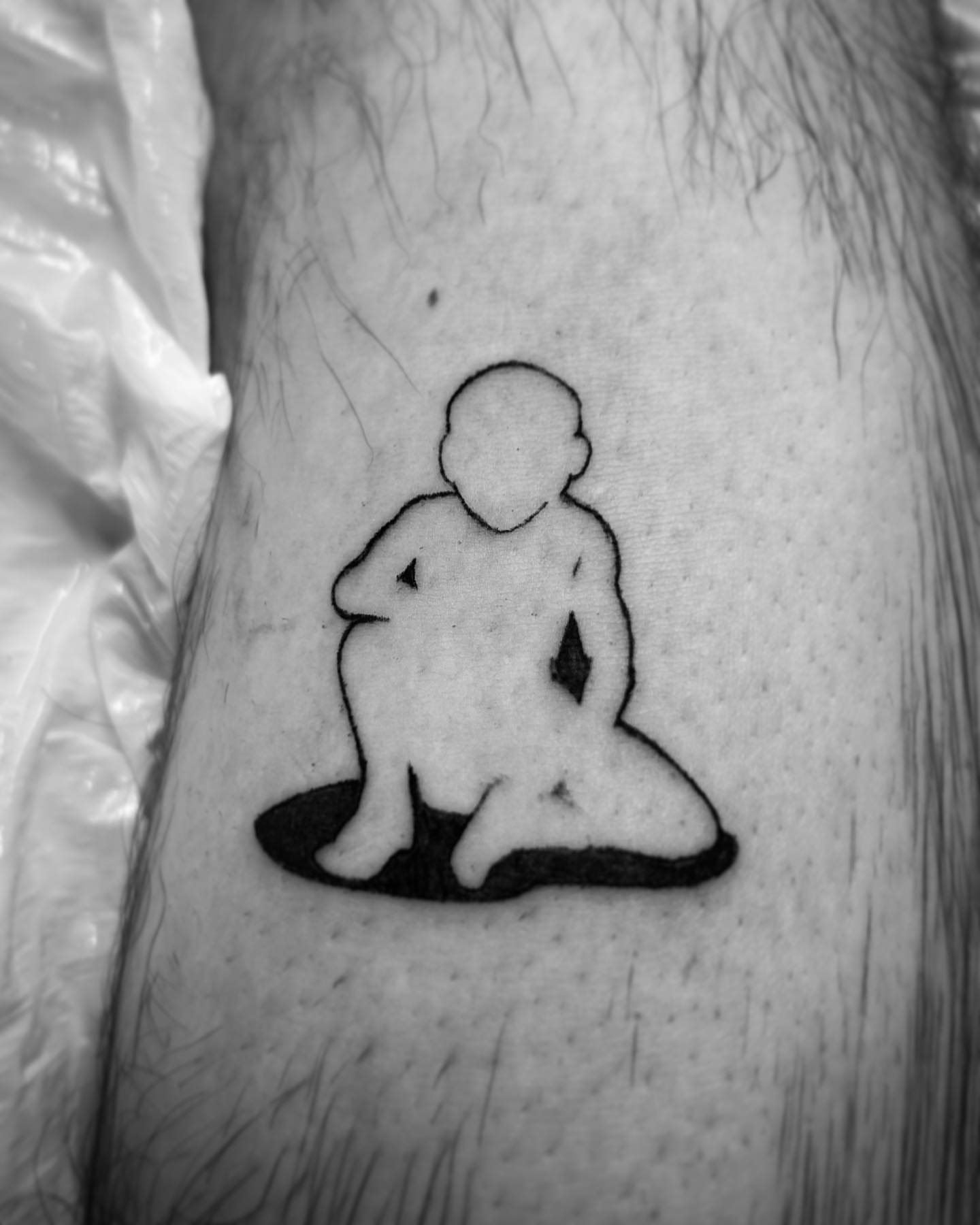 Meditating figure minimalist tattoo on the forearm by Bear