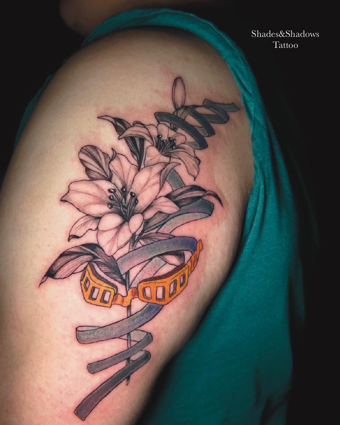 Lilies and film strip realism tattoo on the shoulder by Austin Tattoo Artist