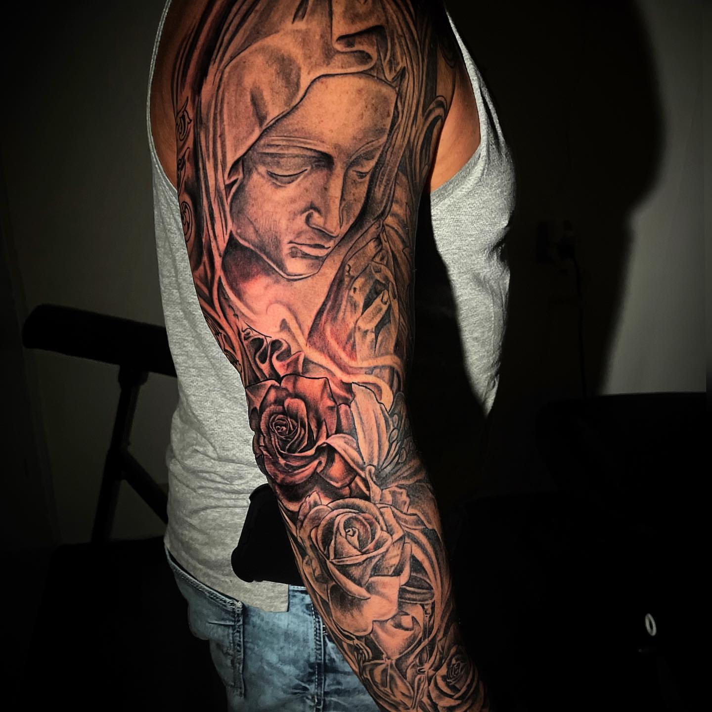 Religious figure with roses realism tattoo on the upper arm by Ohio Realism Tattoo Artist
