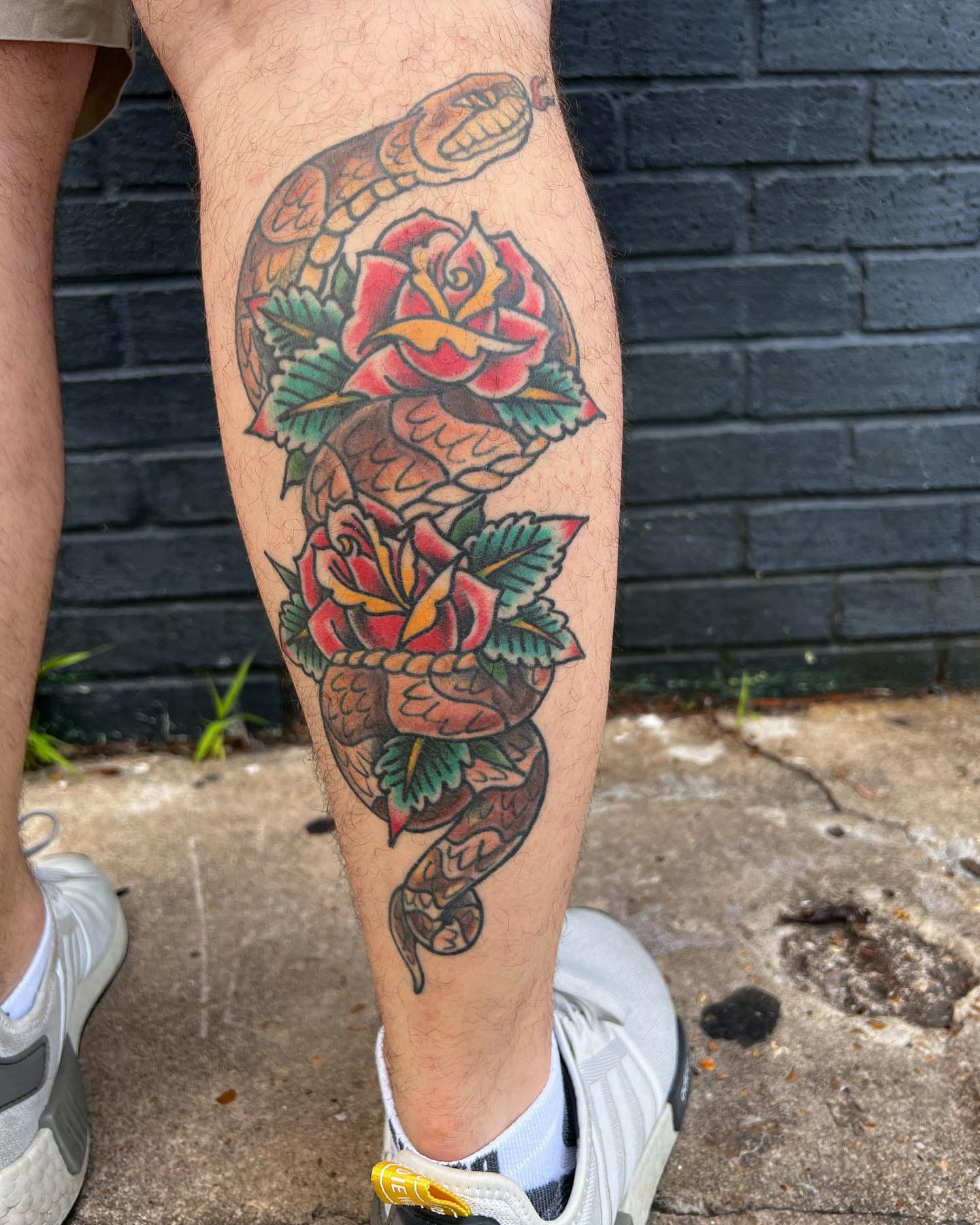 Snake and roses American traditional tattoo on the calf by Scott Allen