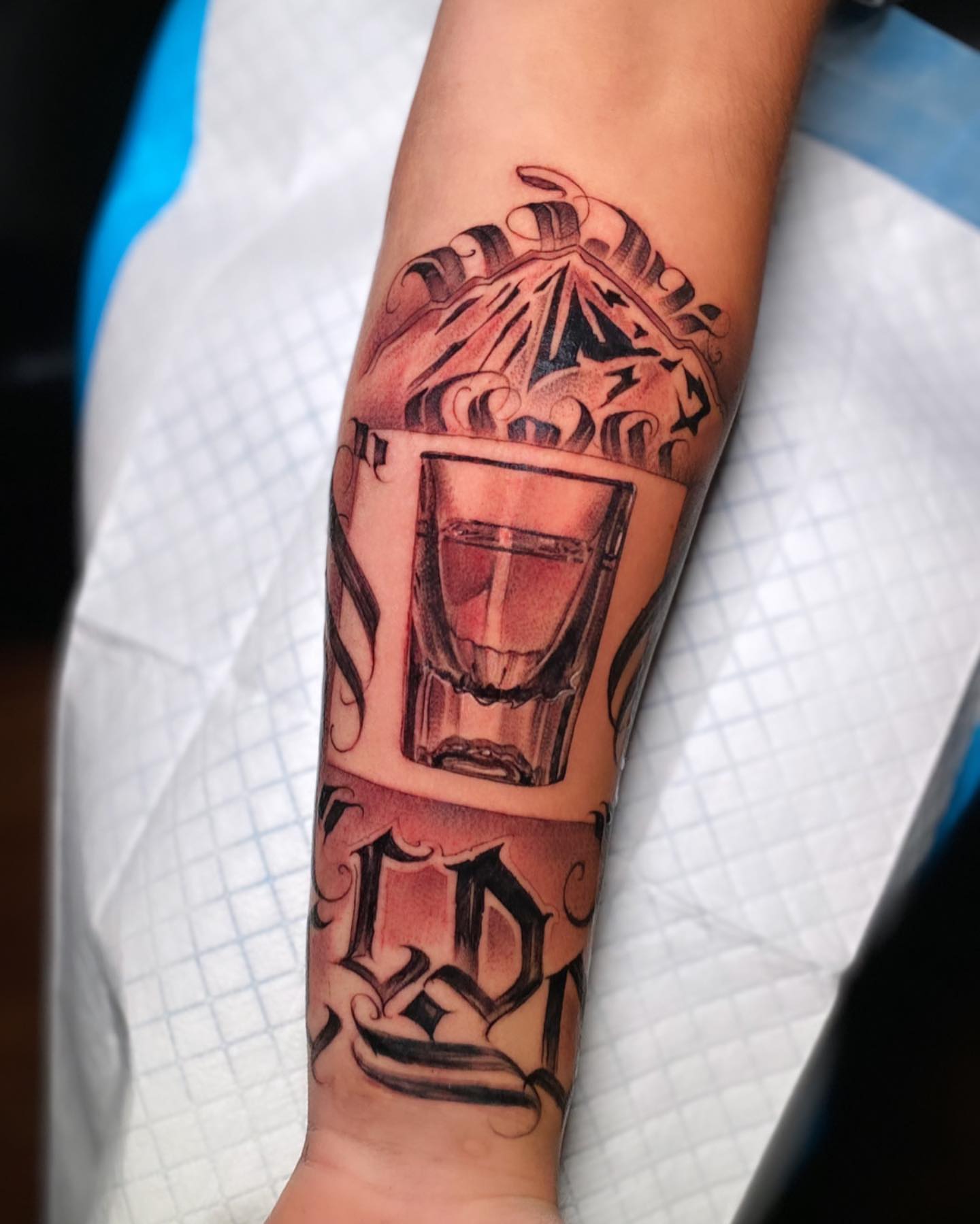 Shot glass American traditional tattoo on the forearm by Jared Soto