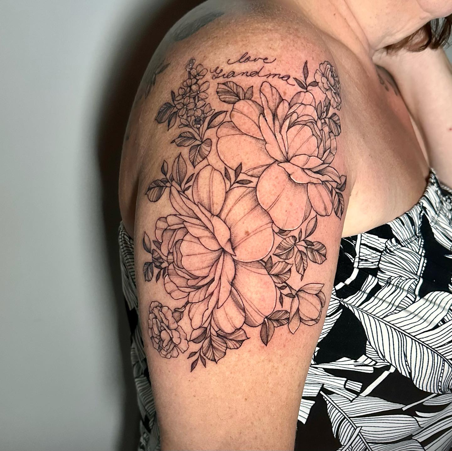 Floral bouquet black and grey tattoo on the shoulder by Megan McKee Tattoo Artist