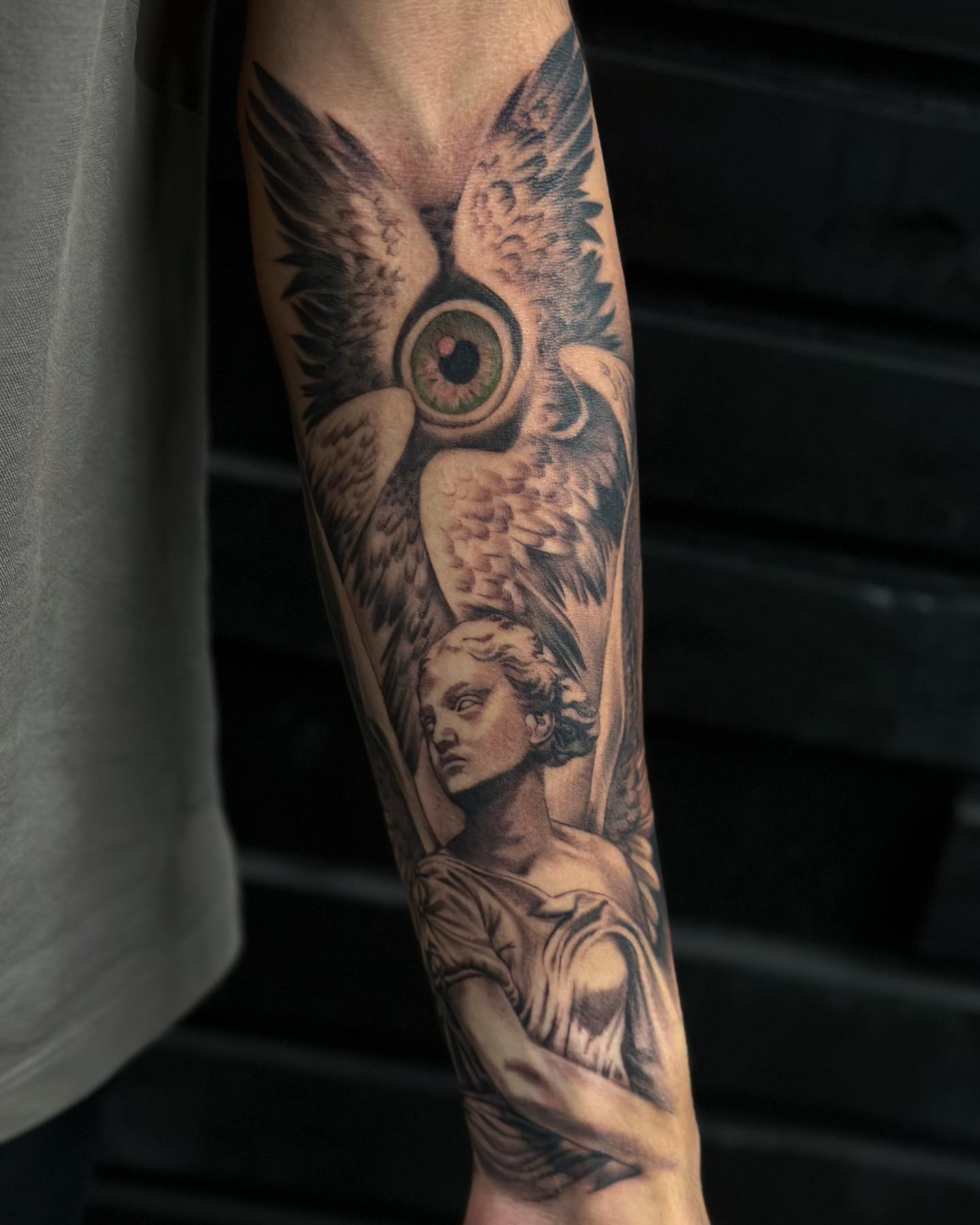 Owl and statue realism tattoo on the forearm by audi