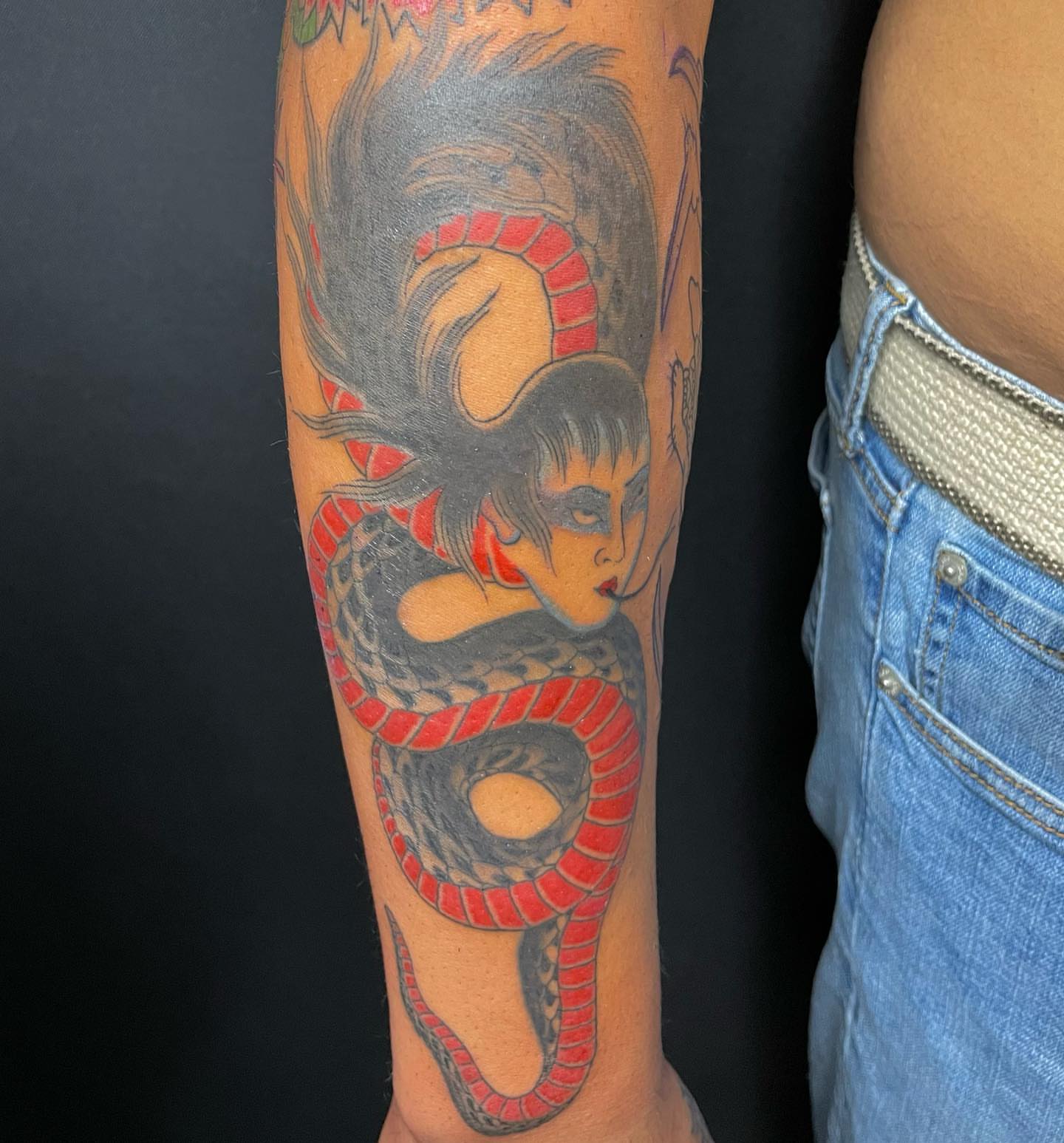 Woman with snake American traditional tattoo on the forearm by Seth Griffin