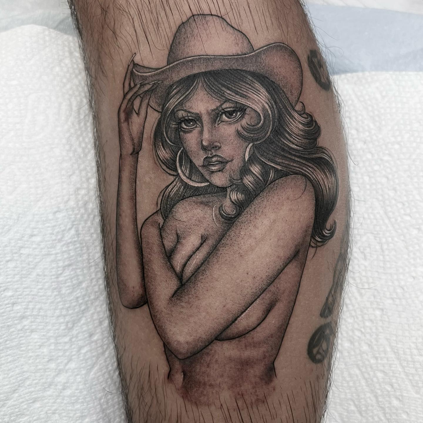 Nude woman with hat realism tattoo on the forearm by Valerie Dominguez