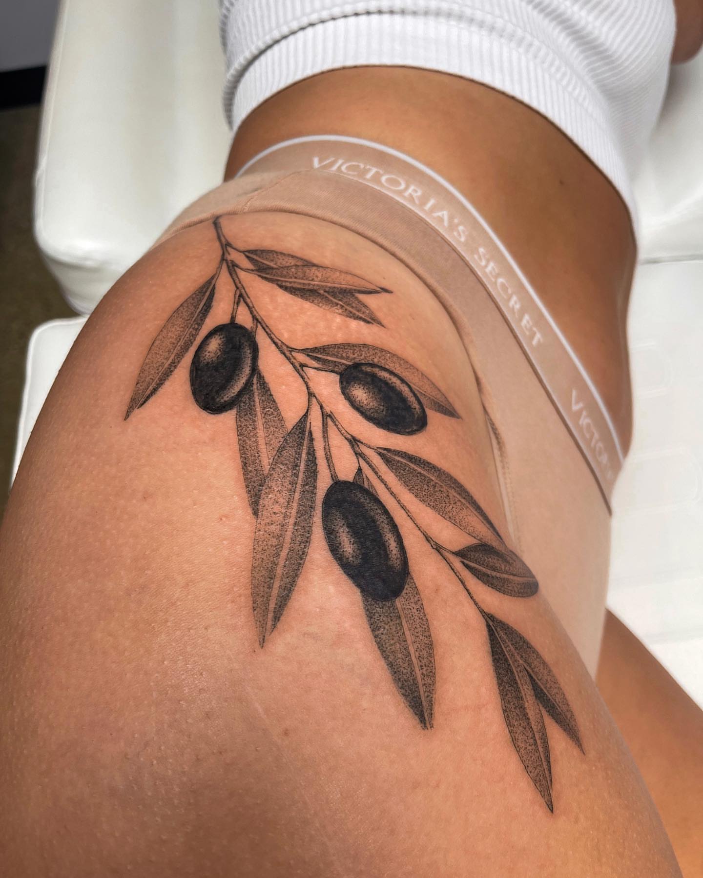 Olive branch dotwork tattoo on the thigh by Michigan Tattoo Artist