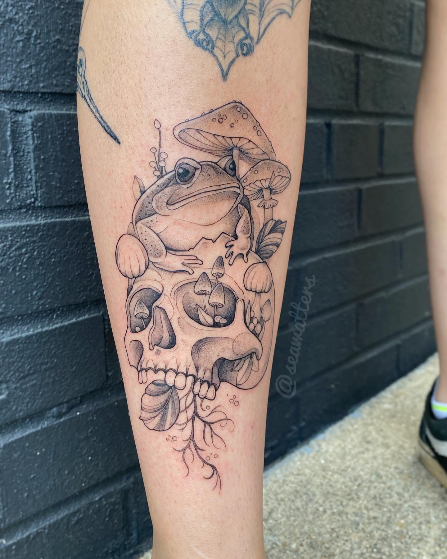 Frog and skull realism tattoo on the forearm by Caitlin Watters