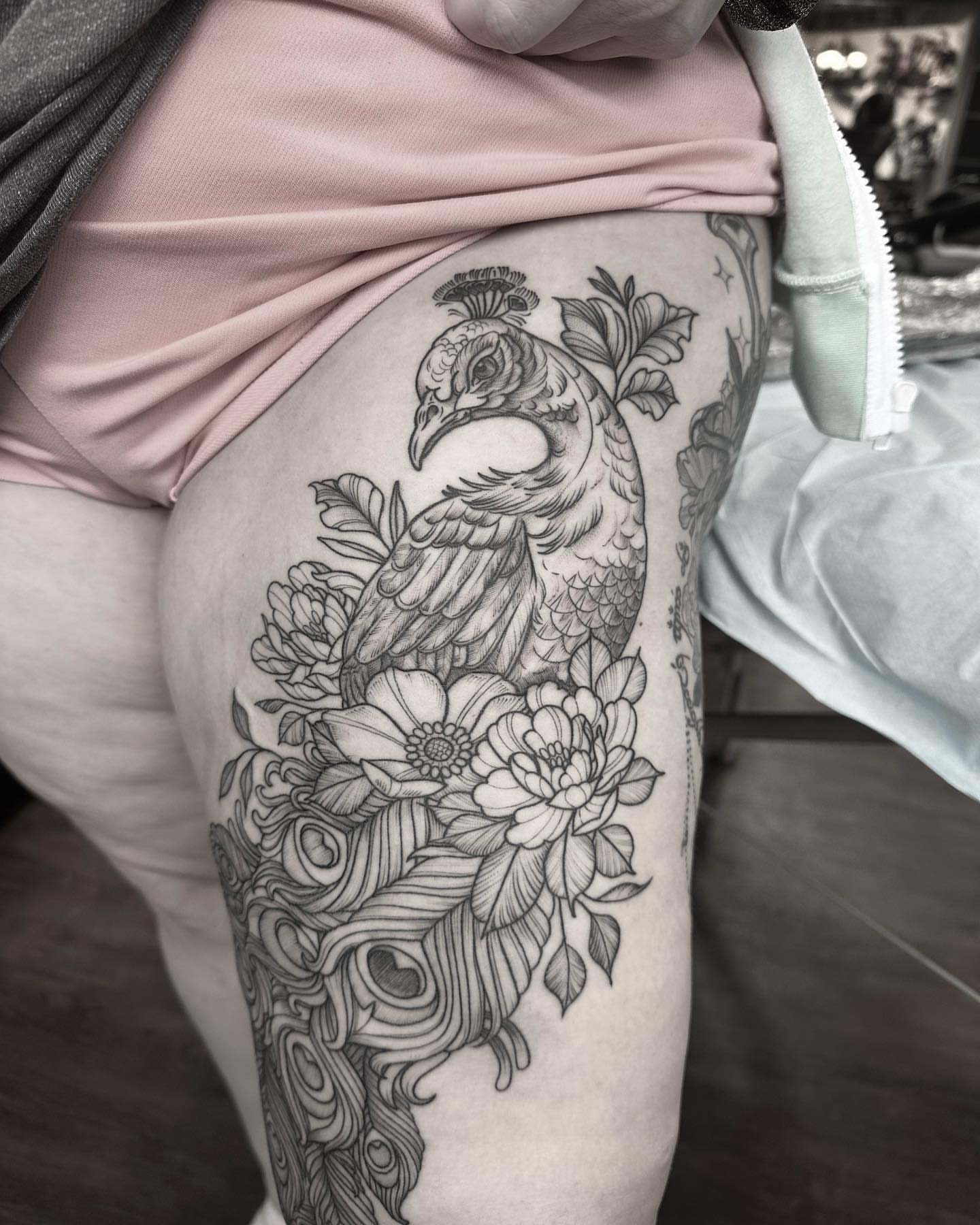 Peacock and floral black and grey tattoo on the thigh by Kirsten Marsden Ballantyne