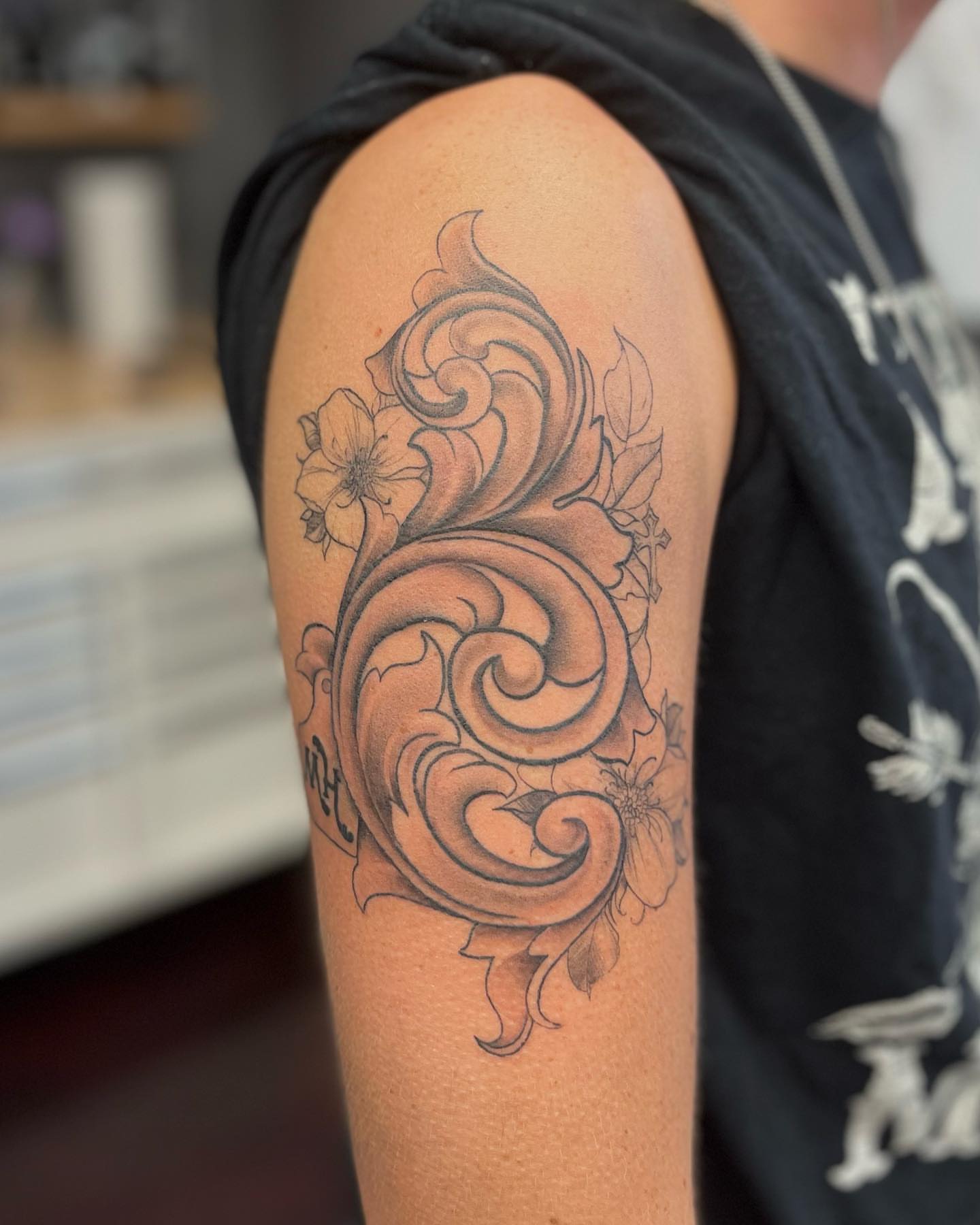 Floral swirl black and grey tattoo on the upper arm by π΄πππ