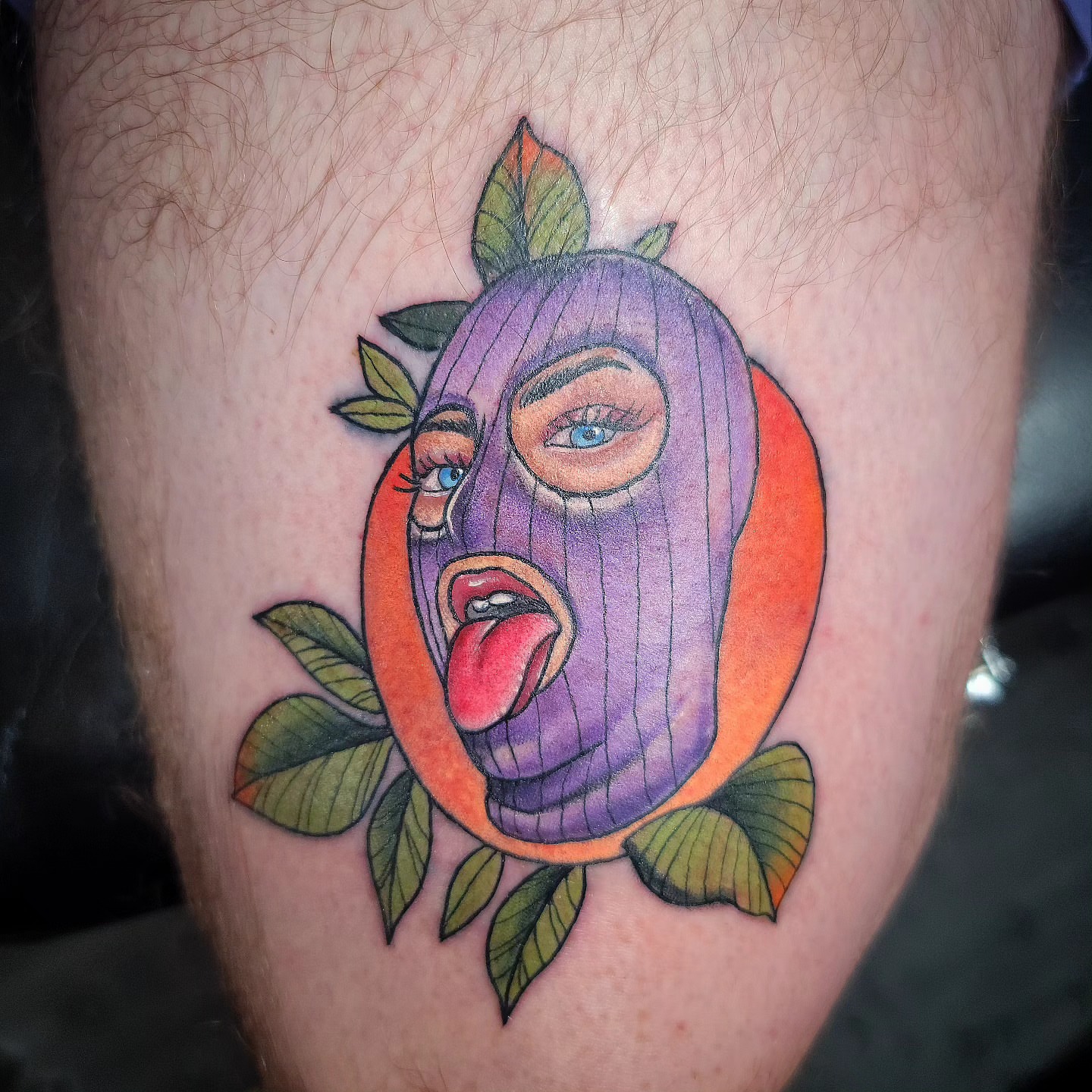 Mask with fruit American traditional tattoo on the thigh by Dick Eckman