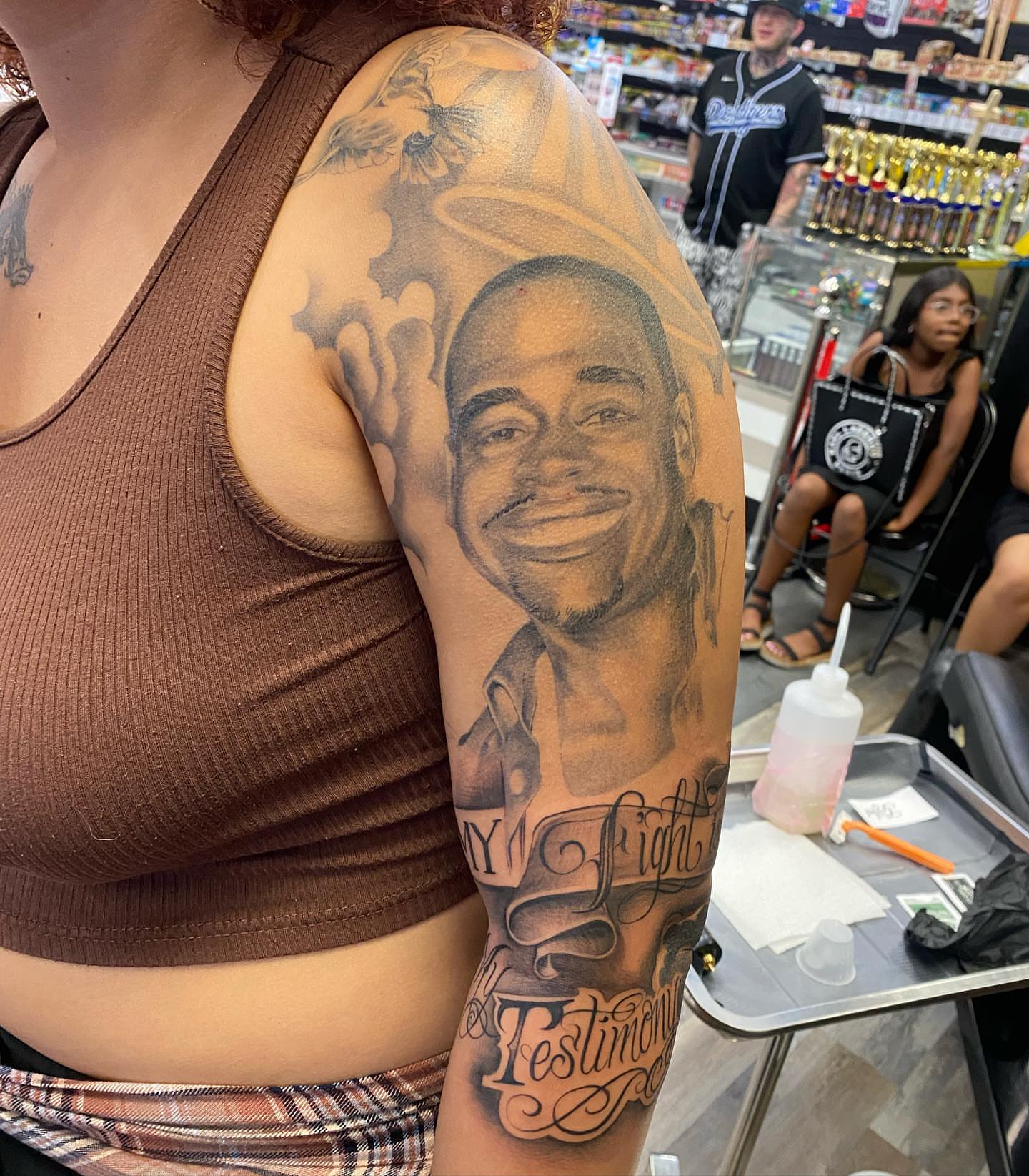 Portrait of a smiling man realism tattoo on the shoulder by Living Life In The Gray Area