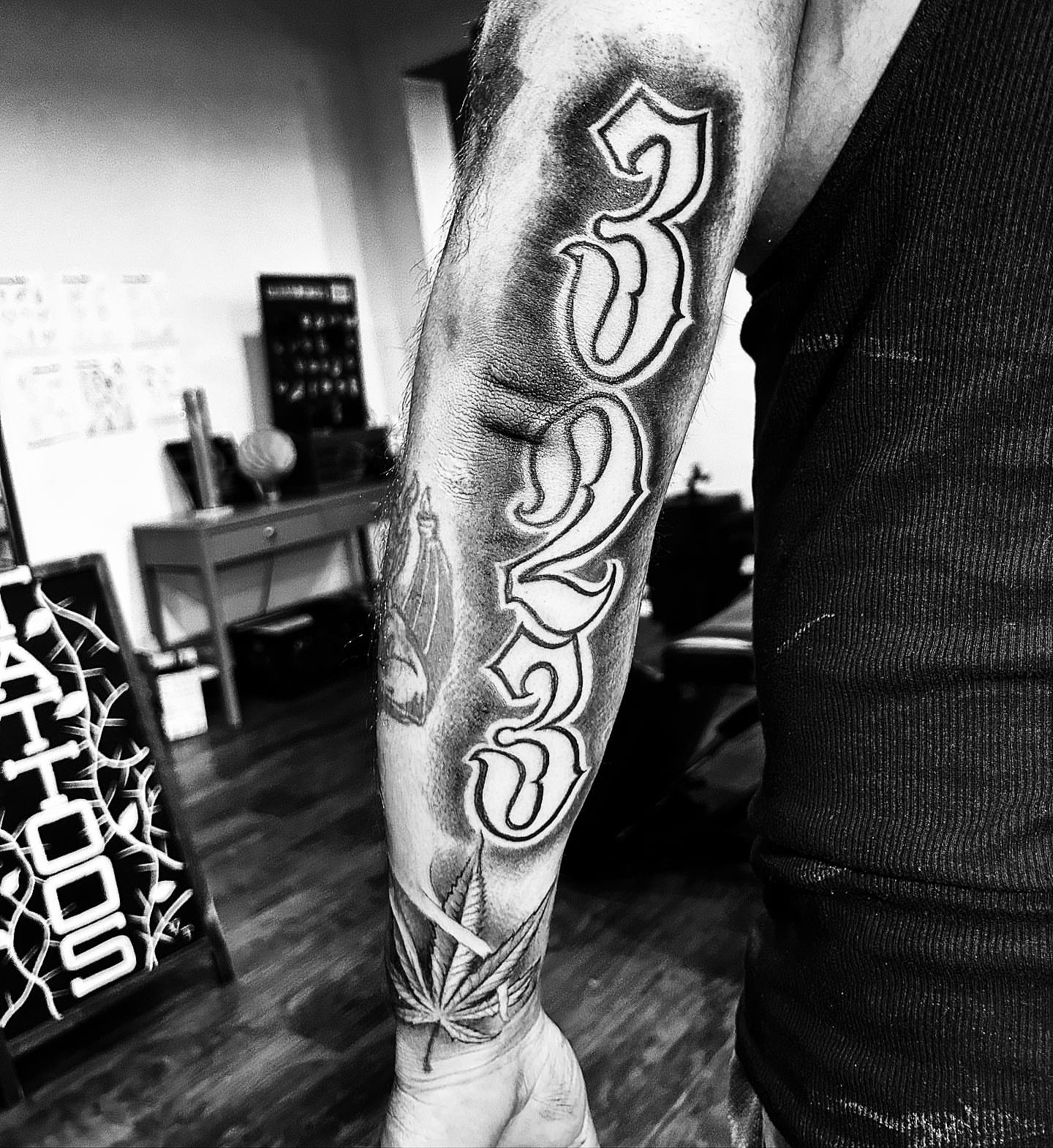 Numbers black and grey tattoo on the forearm by Visionary Tattoos