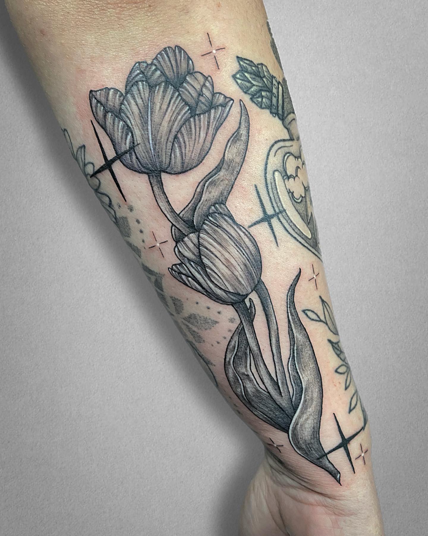 Tulips black and grey tattoo on the forearm by Mallory Miller π³οΈβπ Eugene
