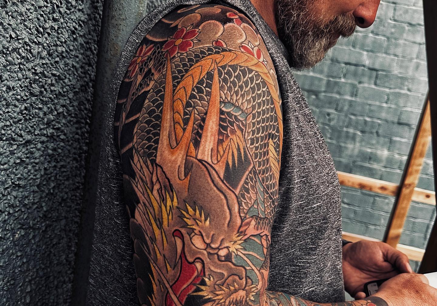 Dragon and phoenix japanese irezumi tattoo on the upper arm by Xiaojun Yin, Vancouver, British Columbia