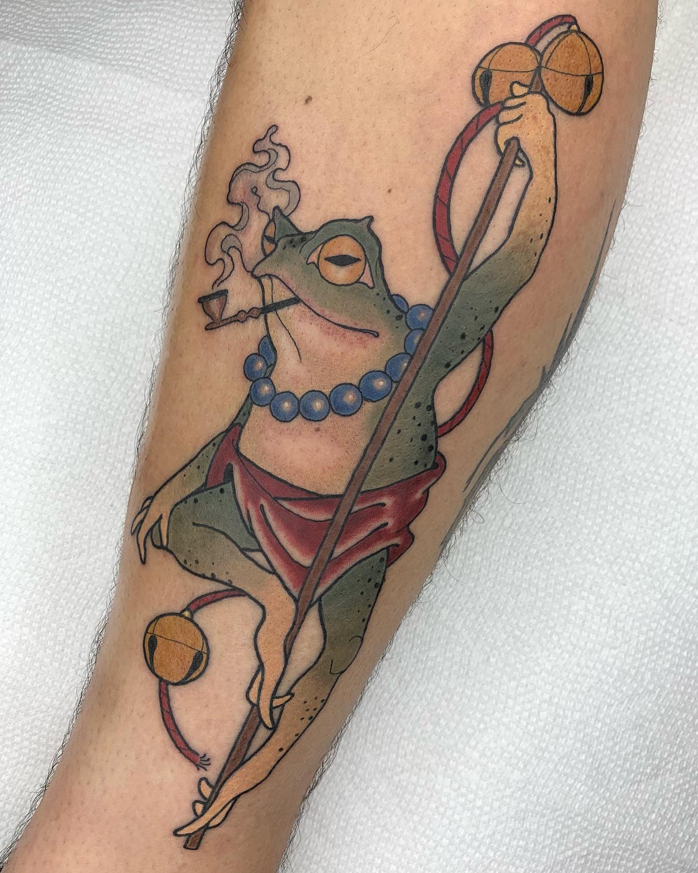 Frog with staff and bells American traditional tattoo on the forearm by Luis Torres, Harrison, New Jersey
