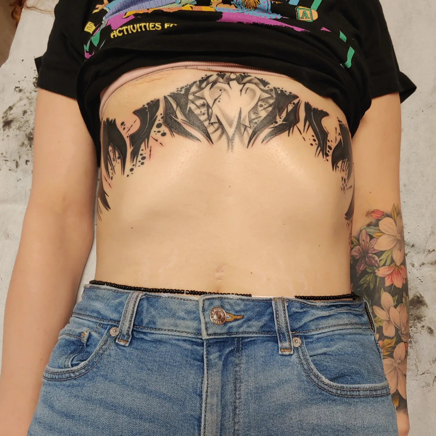 Abstract design black and grey tattoo on the torso by Gene Britton
