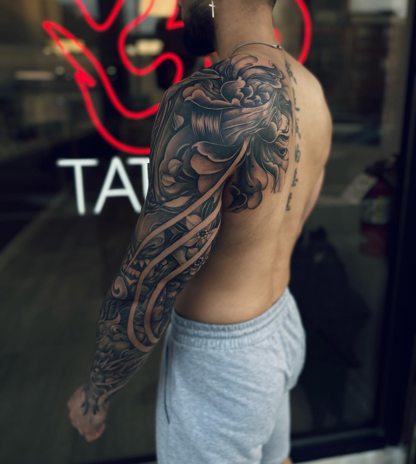 Floral design black and grey tattoo on the upper arm by Jennal Wang