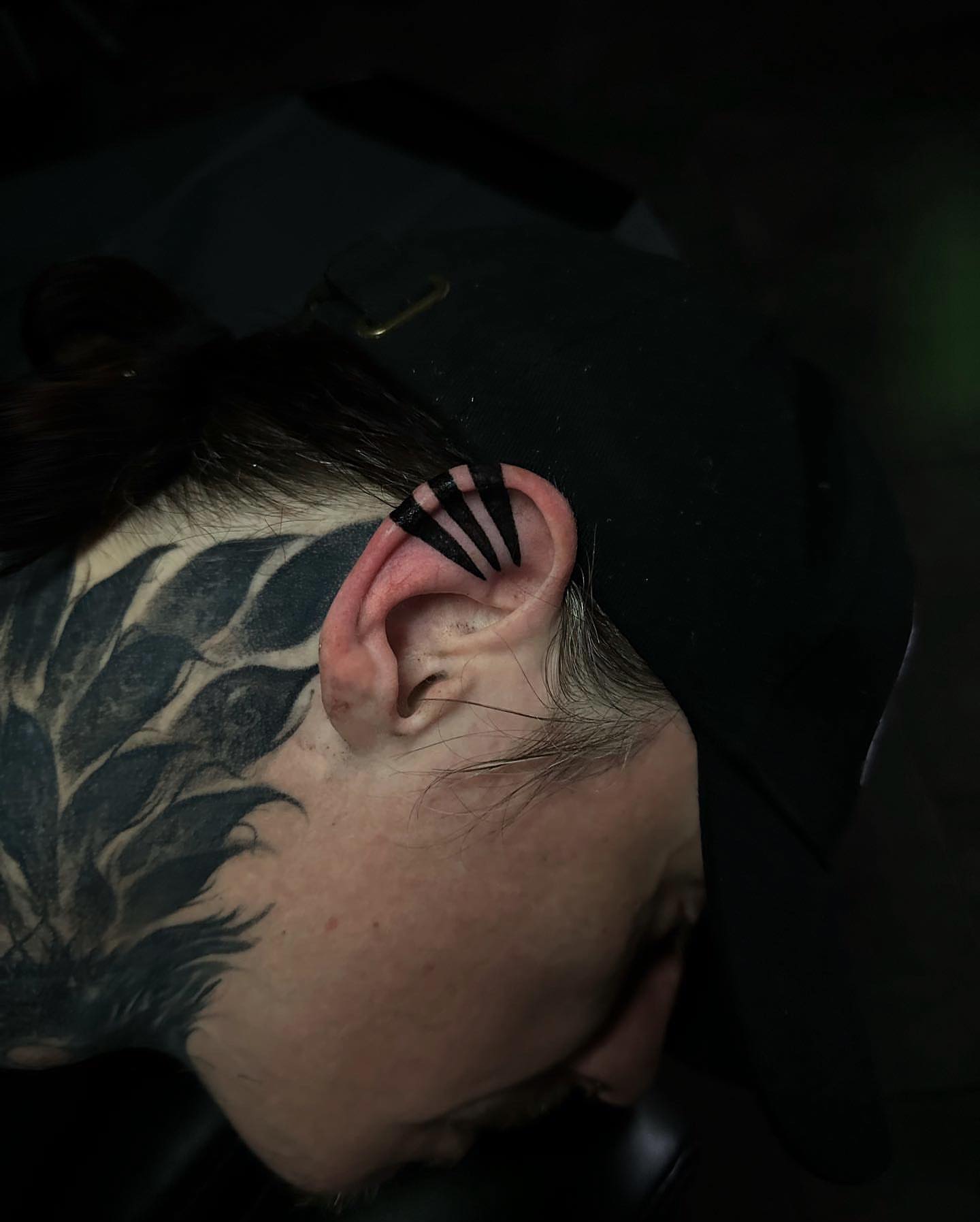 Ear piercing black and grey tattoo on the head by Ryan K Severe