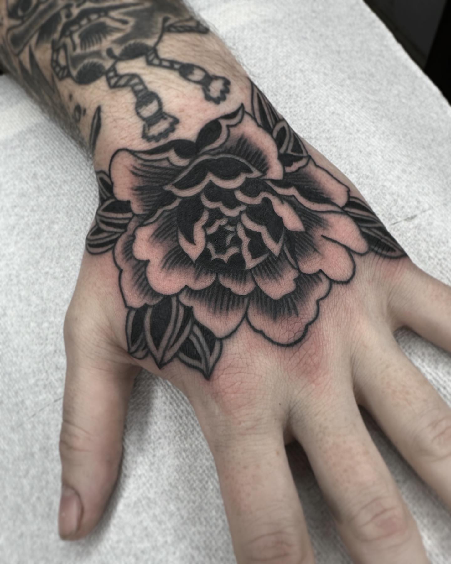 Peony American traditional tattoo on the hand by Elijah Edwards