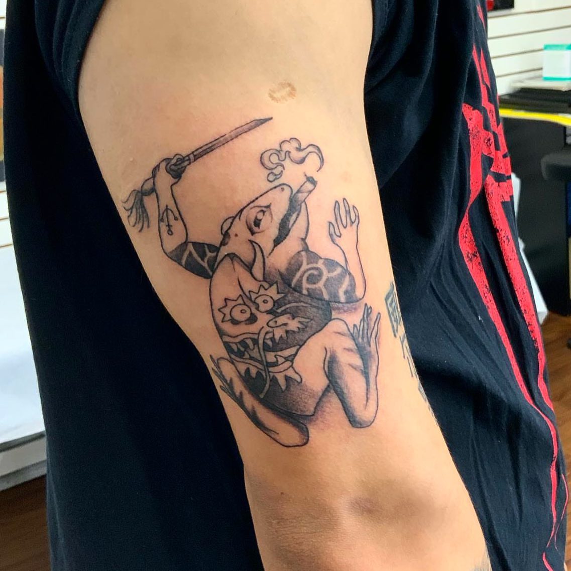 Frog with sword black and grey tattoo on the forearm by Ride The Needle Tattoos, New Britain, Connecticut