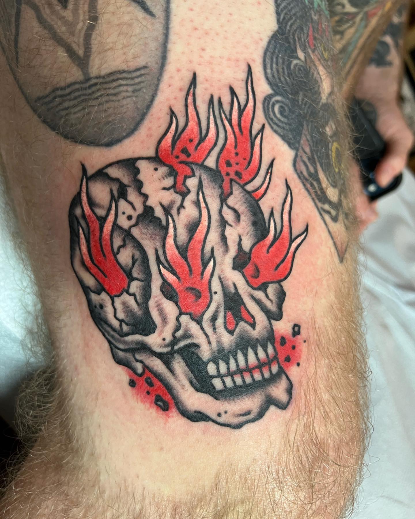 Flaming skull neo-traditional tattoo on the thigh by Ross K. Jones Tattoos, San Francisco, California