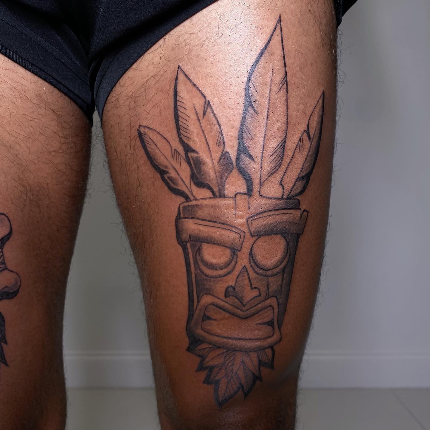 Tribal mask tribal tattoo on the thigh by Hailey K - Arizona Tattoo Artist, Miami, Florida