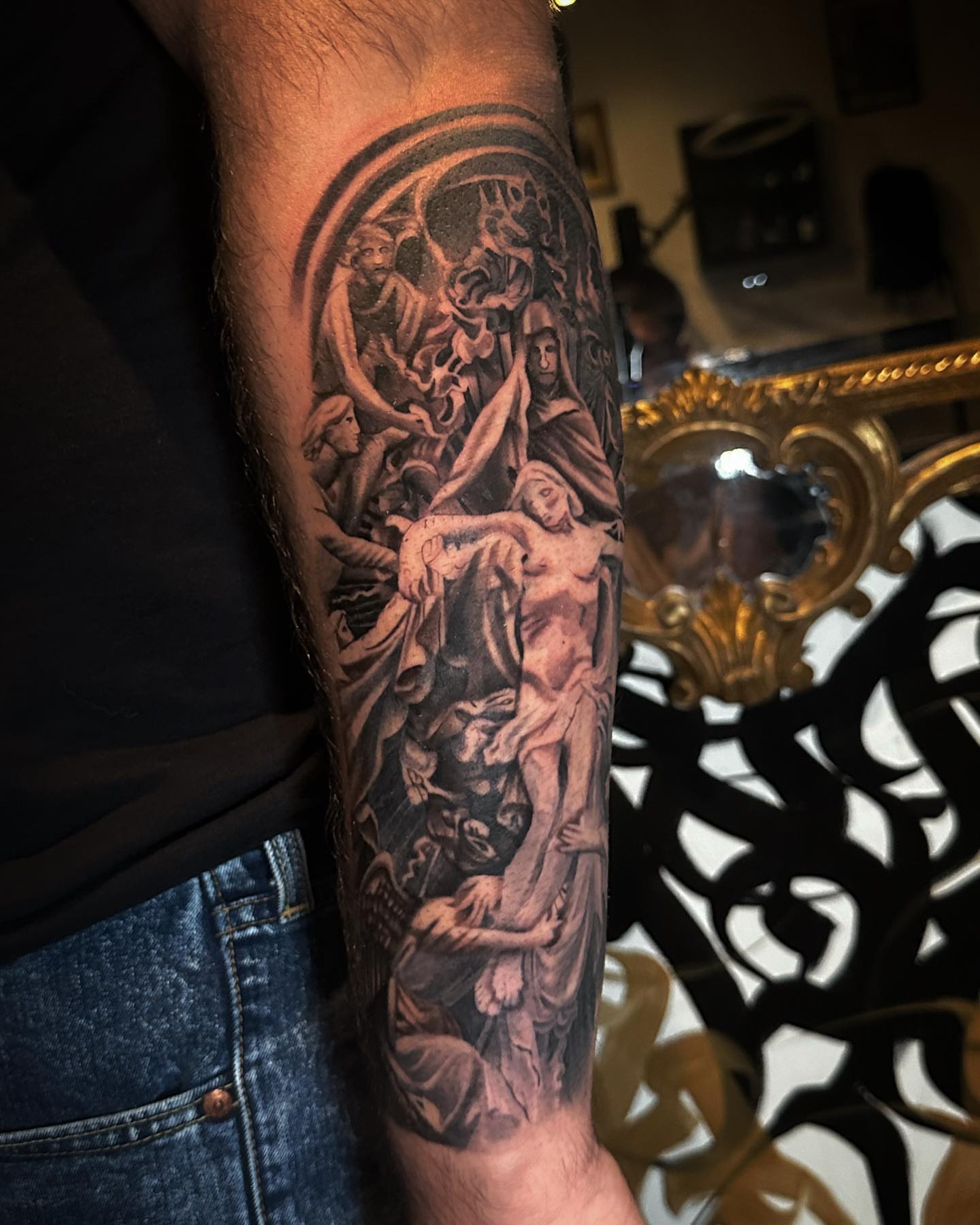 Pieta scene realism tattoo on the forearm by Geo