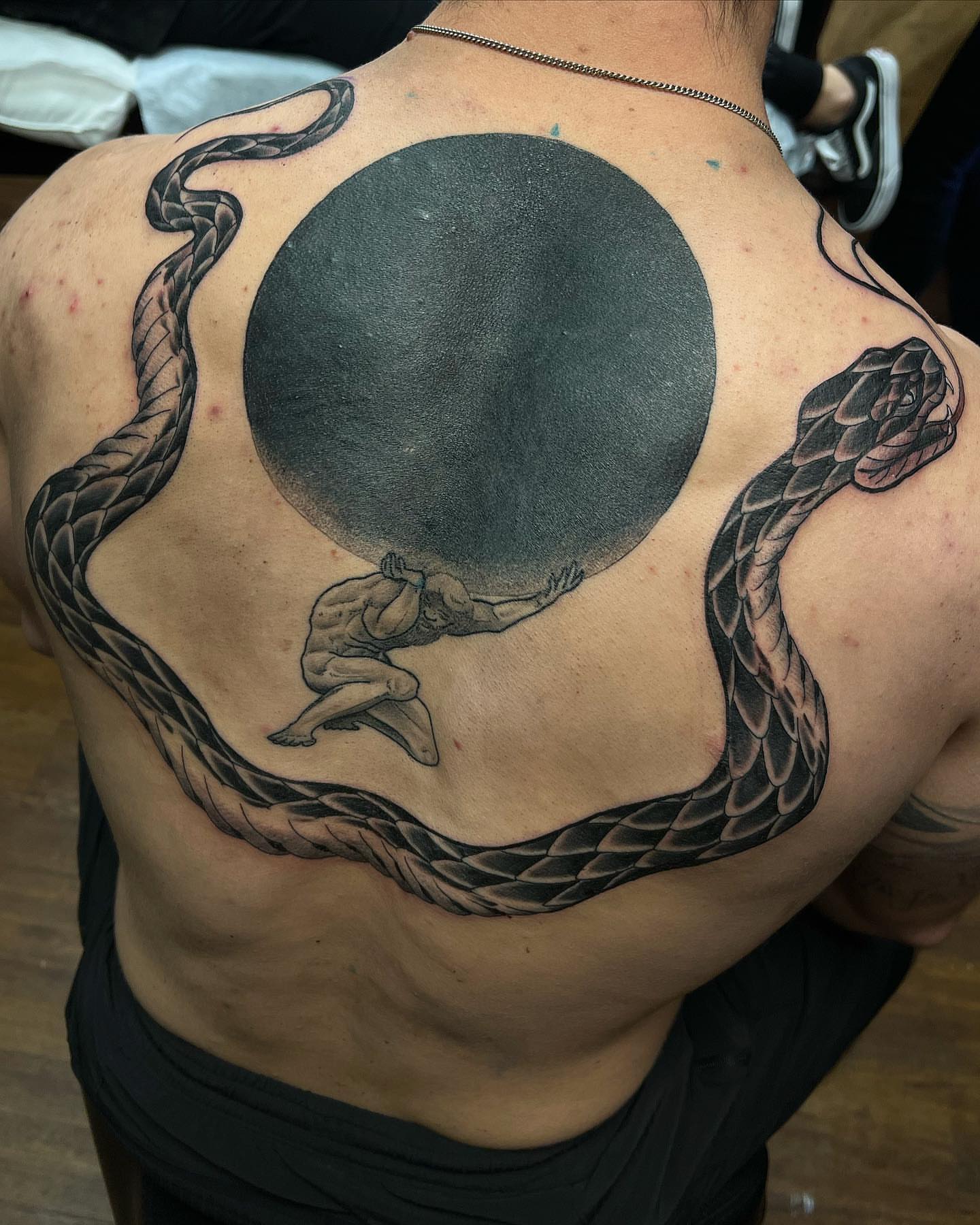 Man holding moon realism tattoo on the back by Daniel Patrick