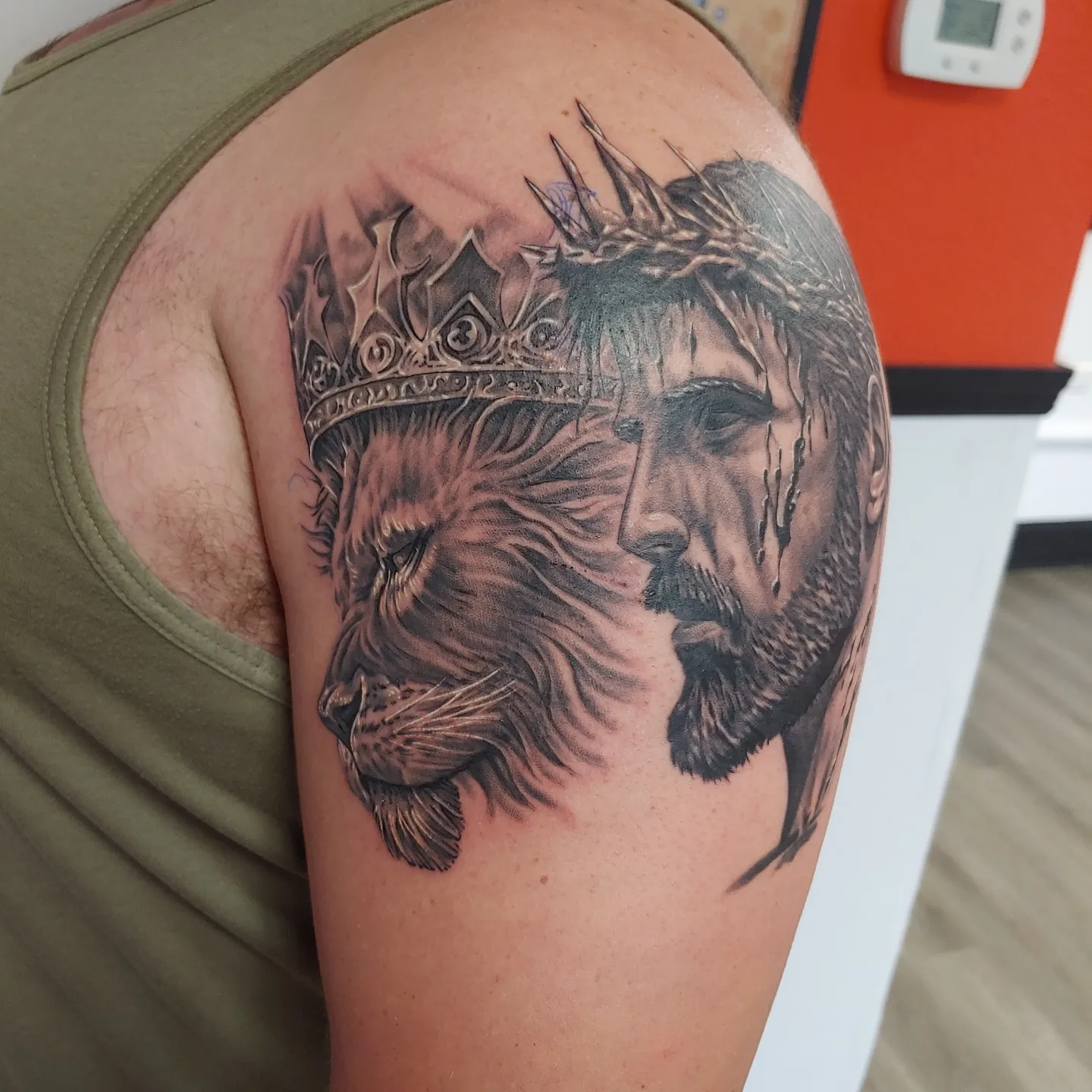 Lion and man realism tattoo on the shoulder by Gene Britton