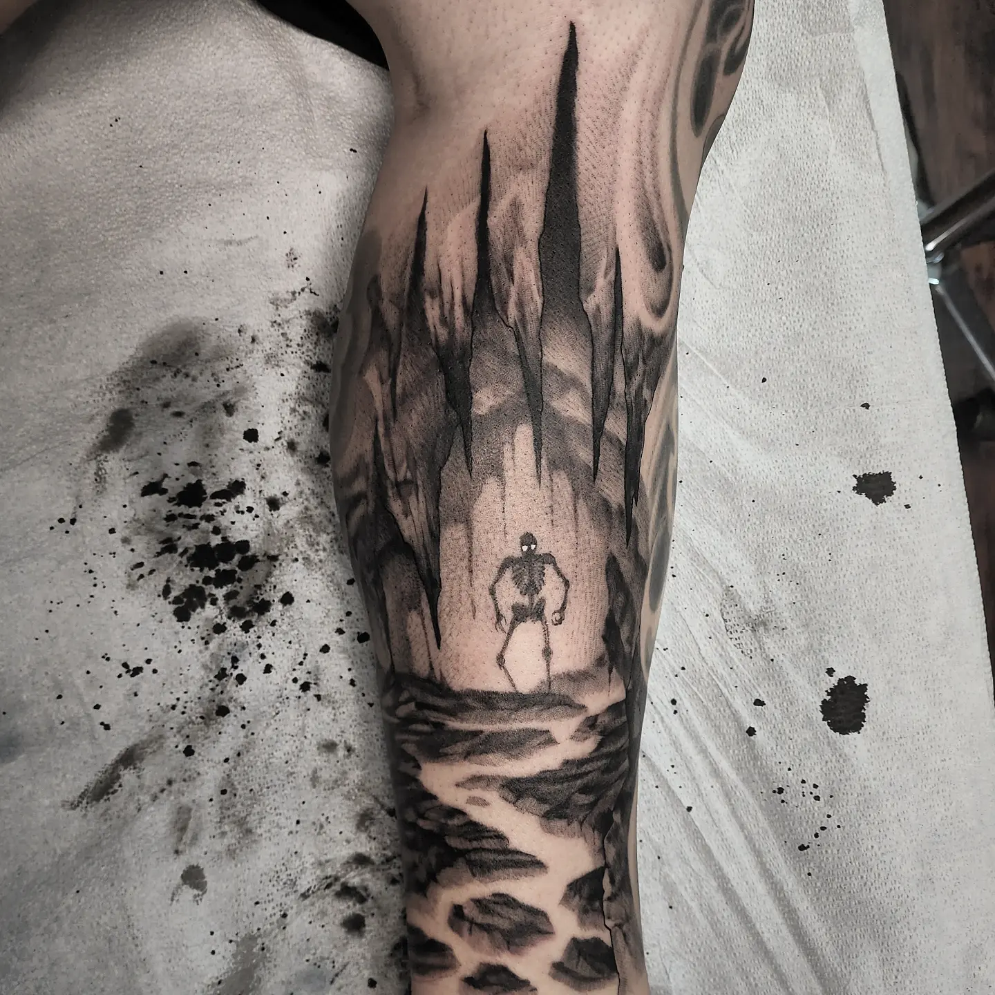 Dark cave with skeleton dotwork tattoo on the forearm by Dani Ryan