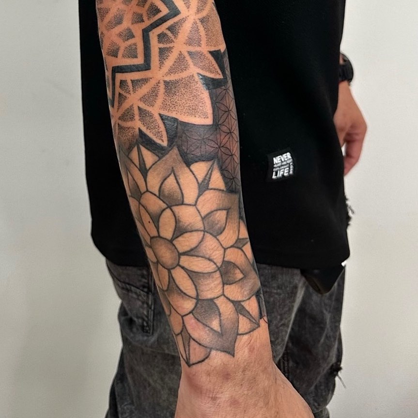 Geometric floral pattern dotwork tattoo on the forearm by NYC