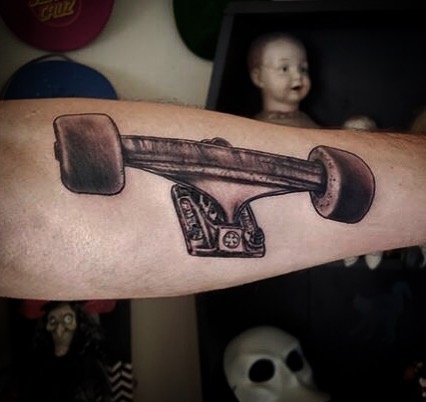 Skateboard black and grey tattoo on the forearm by Bobby Trefz