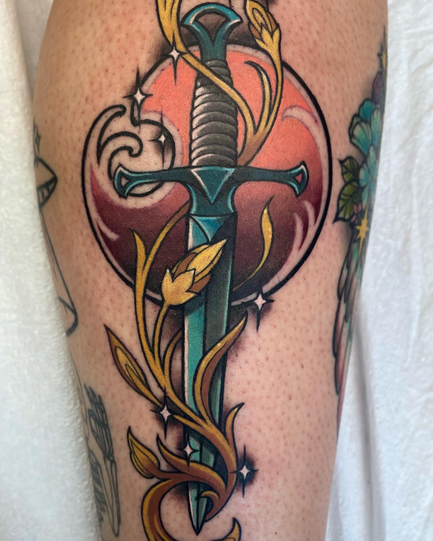 Sword and flowers American traditional tattoo on the forearm by Bri