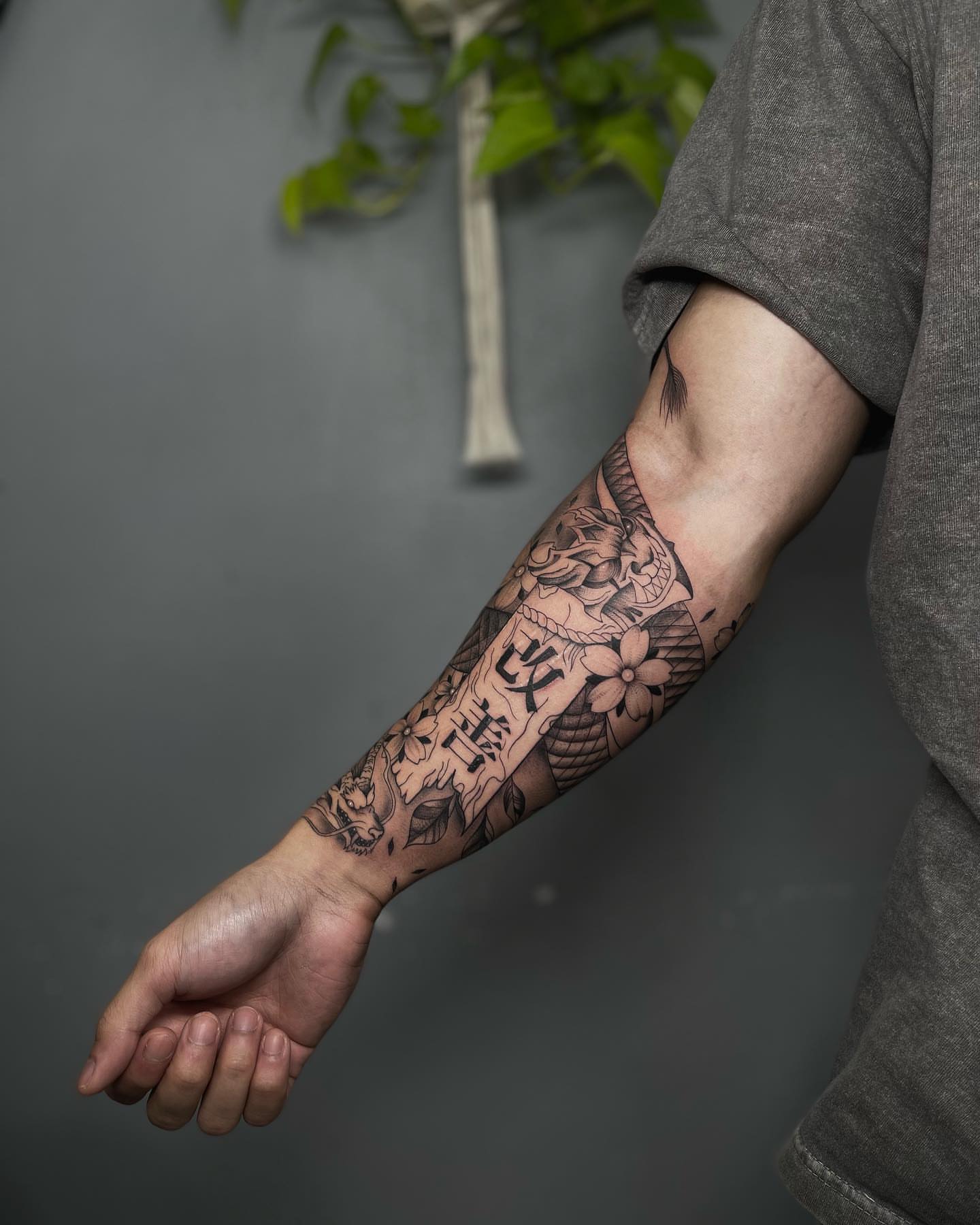 Floral and script black and grey tattoo on the forearm by Beans