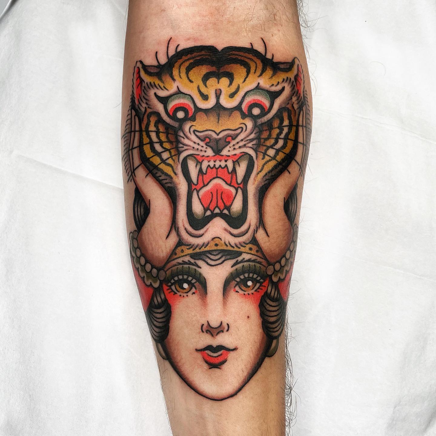 Woman with tiger American traditional tattoo on the forearm by Wes Hoffman