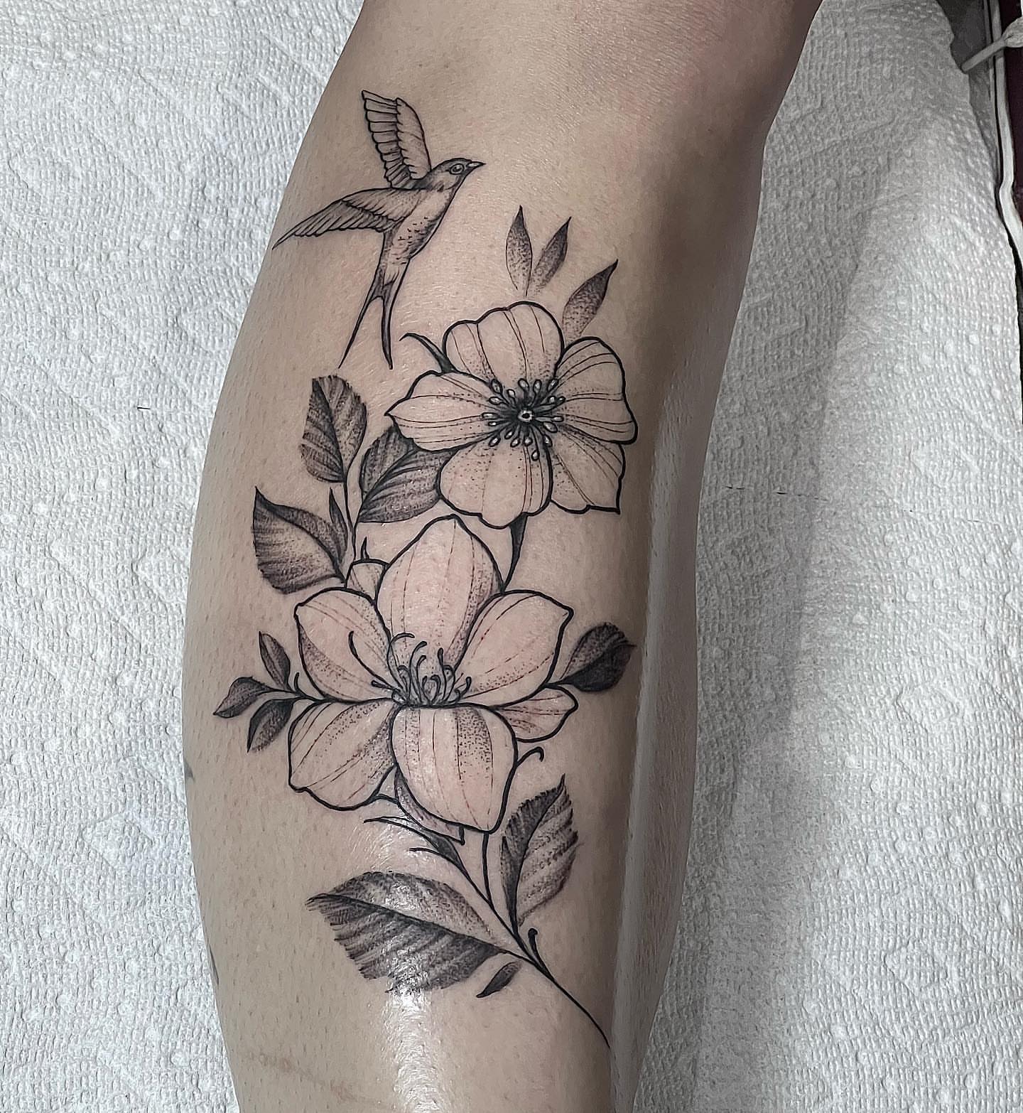 Bird and flowers realism tattoo on the forearm by Eric Axle