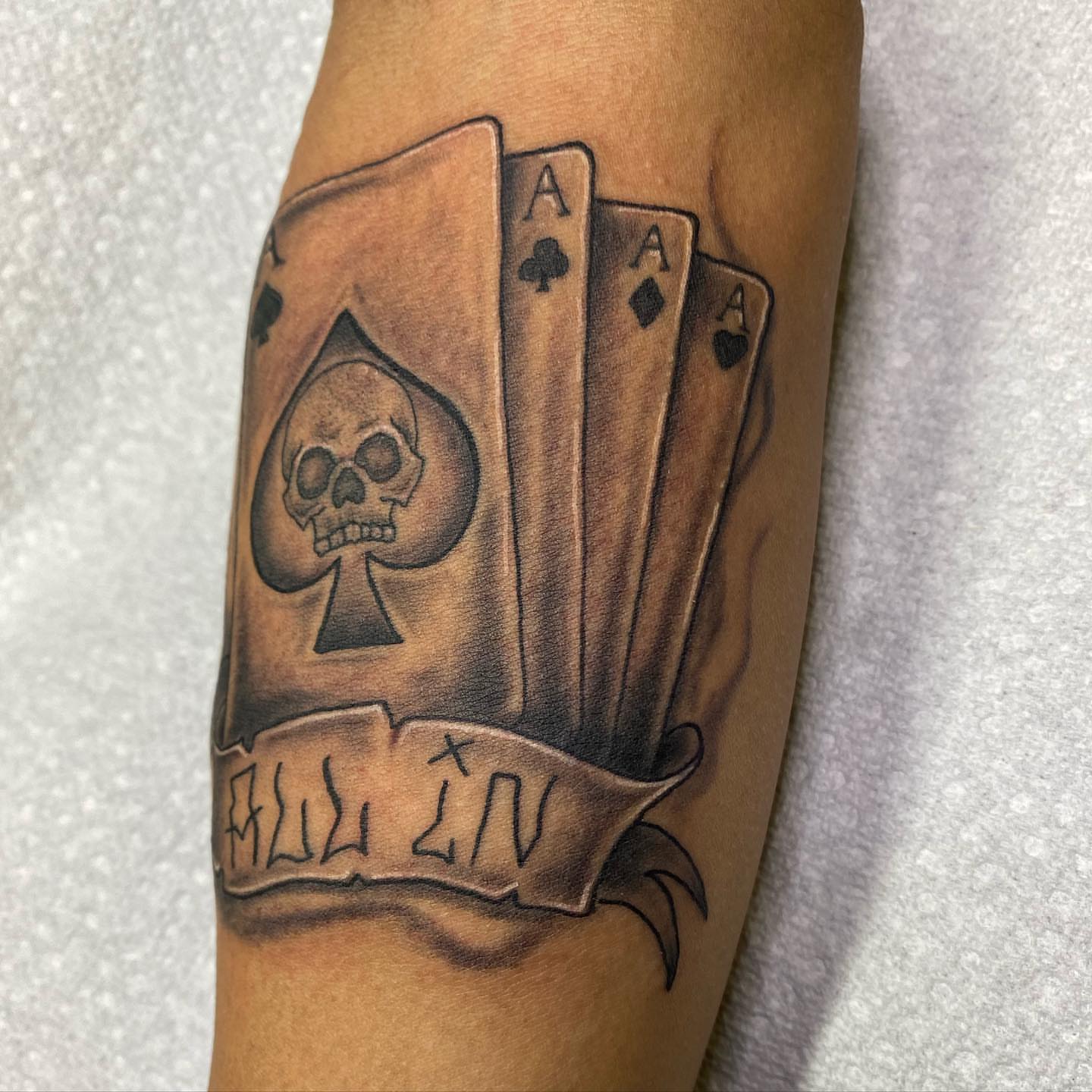 Playing cards and skull realism tattoo on the forearm by Anthony Pichardo 🦇