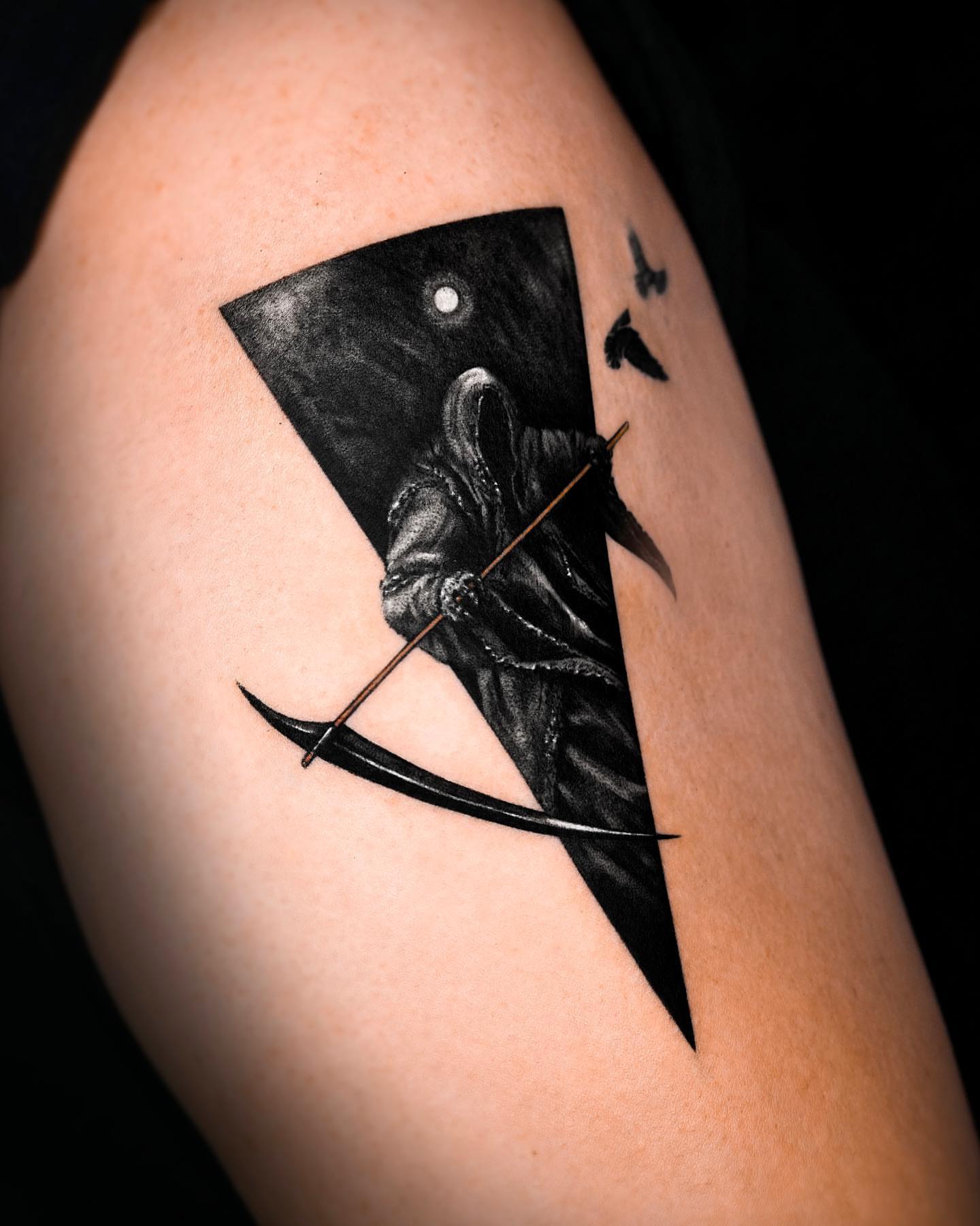Grim reaper dark realism tattoo on the upper arm by Rizn