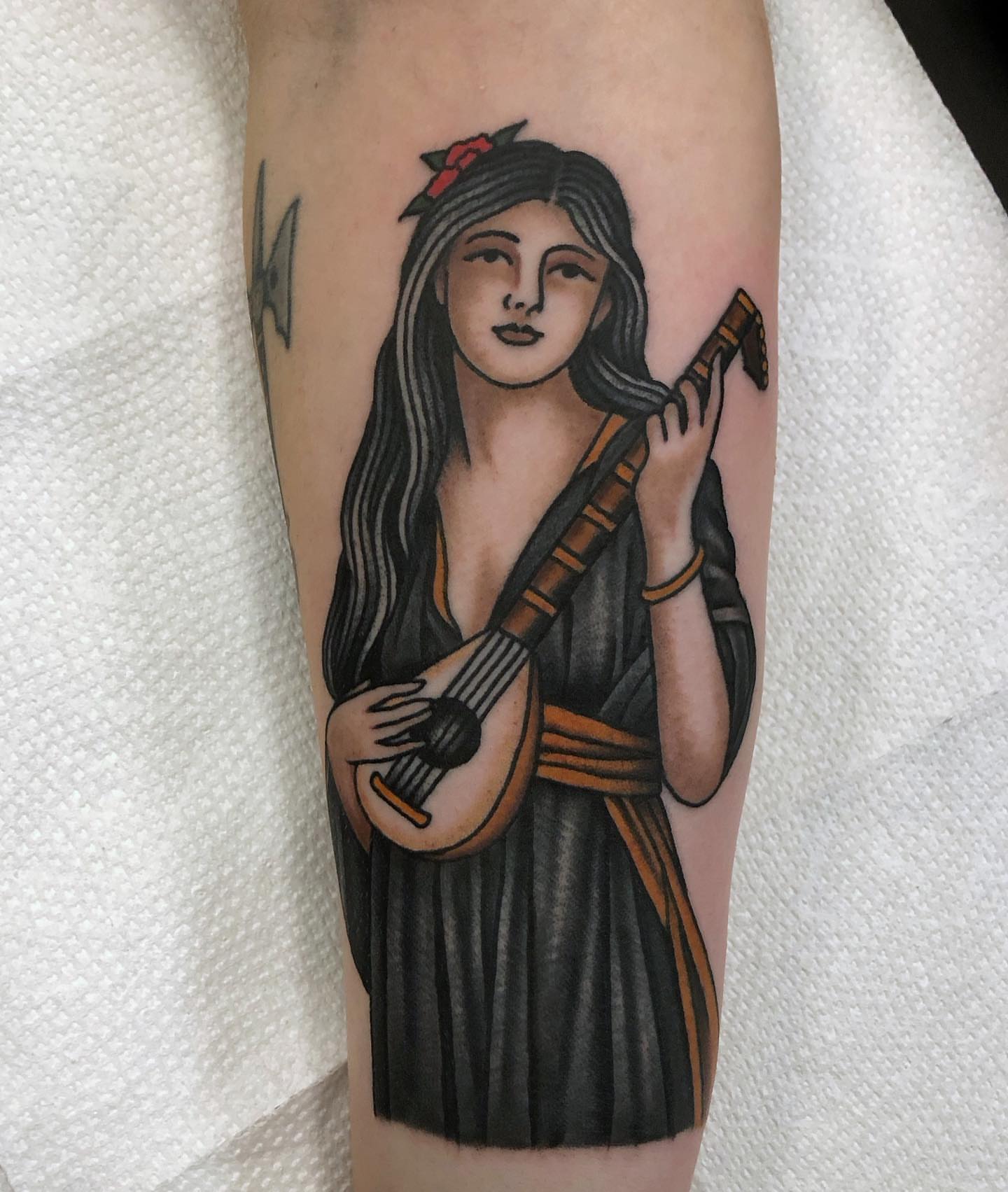 Woman playing lute American traditional tattoo on the forearm by Ben Fiedler
