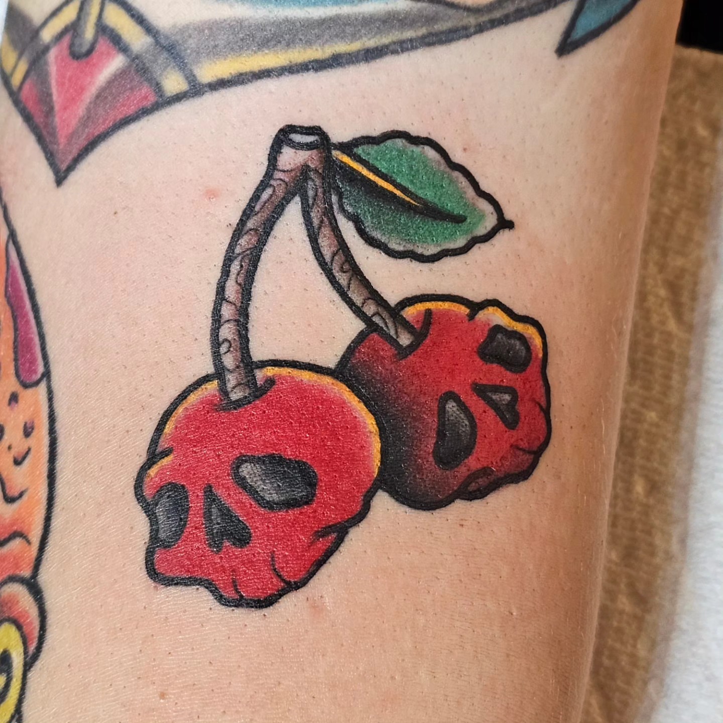 Cherry skulls American traditional tattoo on the forearm by BZ Artistry