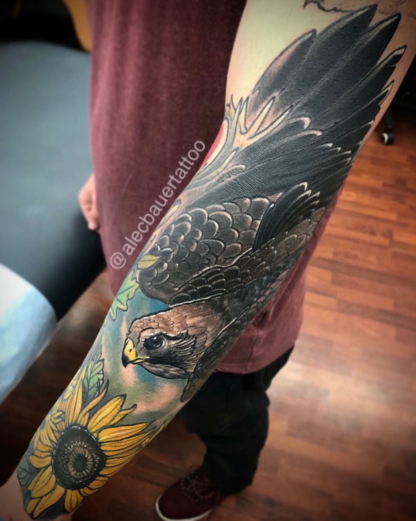 Hawk and sunflower realism tattoo on the forearm by Alec Bauer