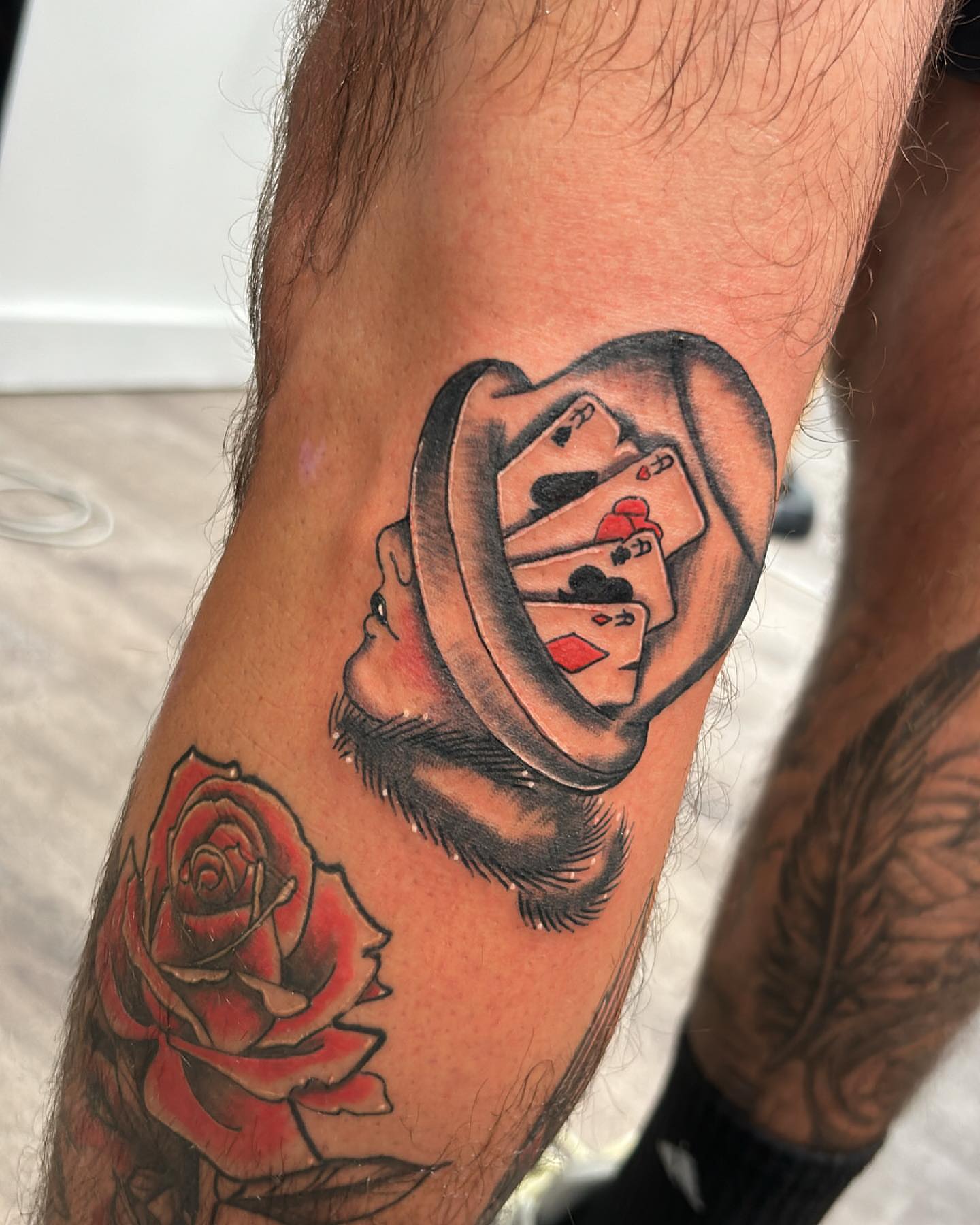 Hat and playing cards American traditional tattoo on the forearm by Edward A. Boesch